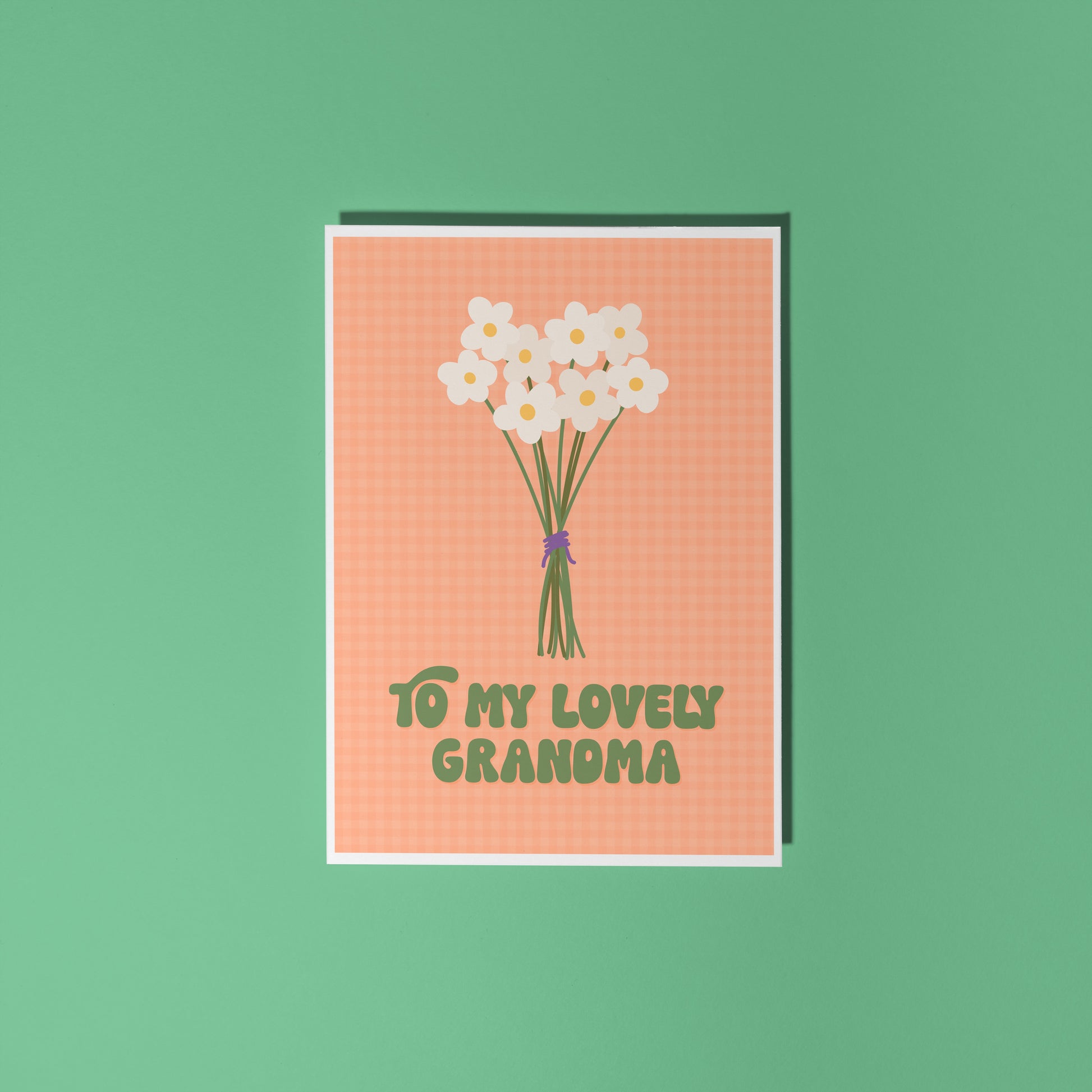 An orange greeting card with the words 'to my lovely Grandma' on the front, with a bunch of daisies.