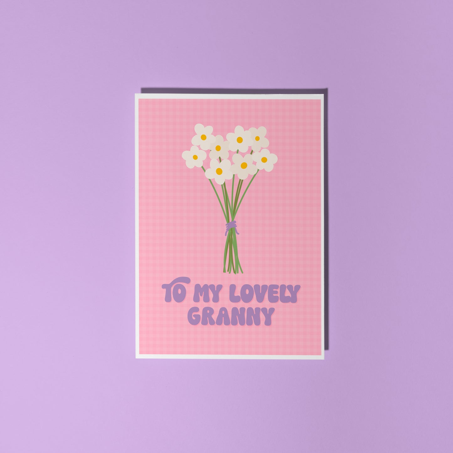 A pink greeting card with the words 'to my lovely Granny' on the front, with a bunch of daisies.