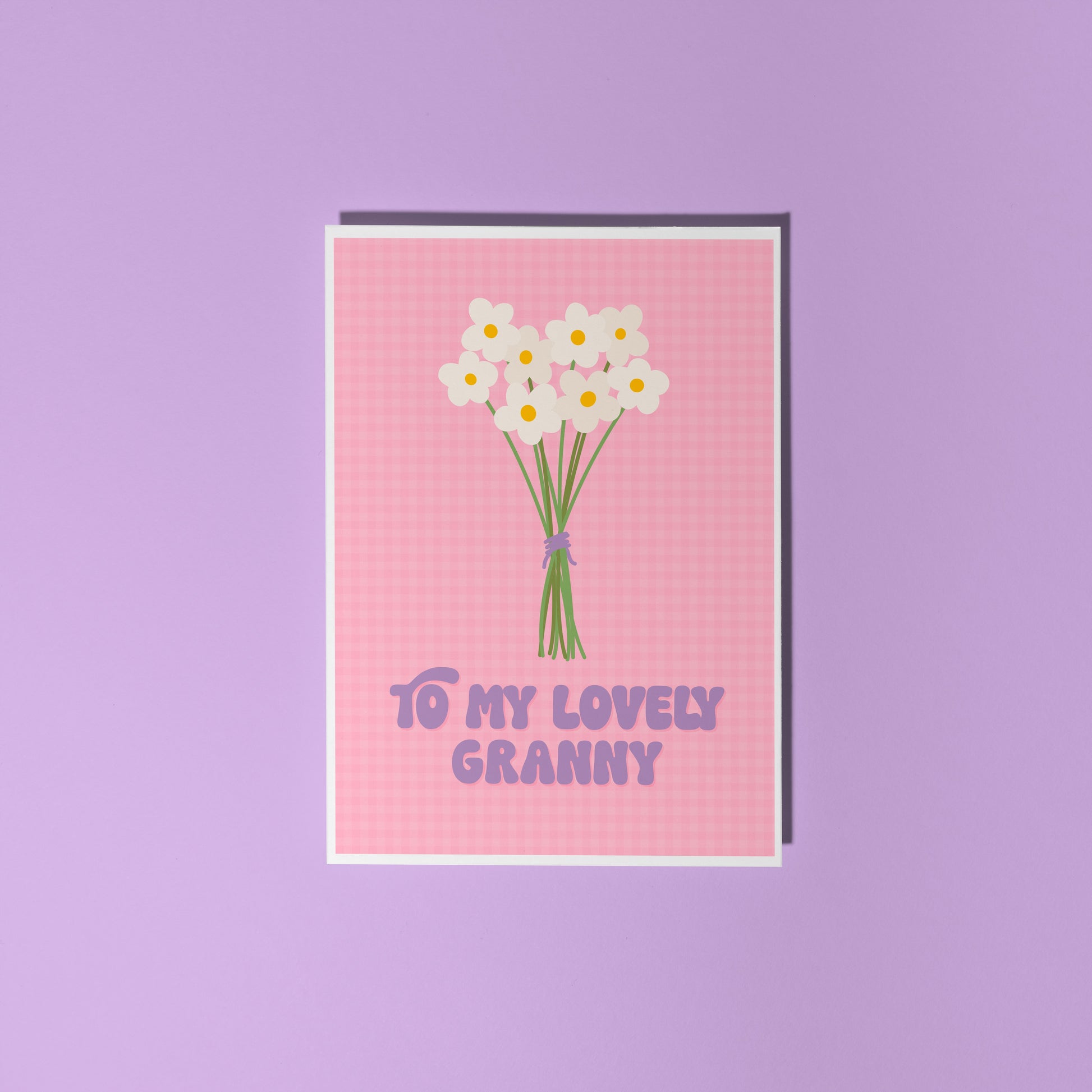 A pink greeting card with the words 'to my lovely Granny' on the front, with a bunch of daisies.
