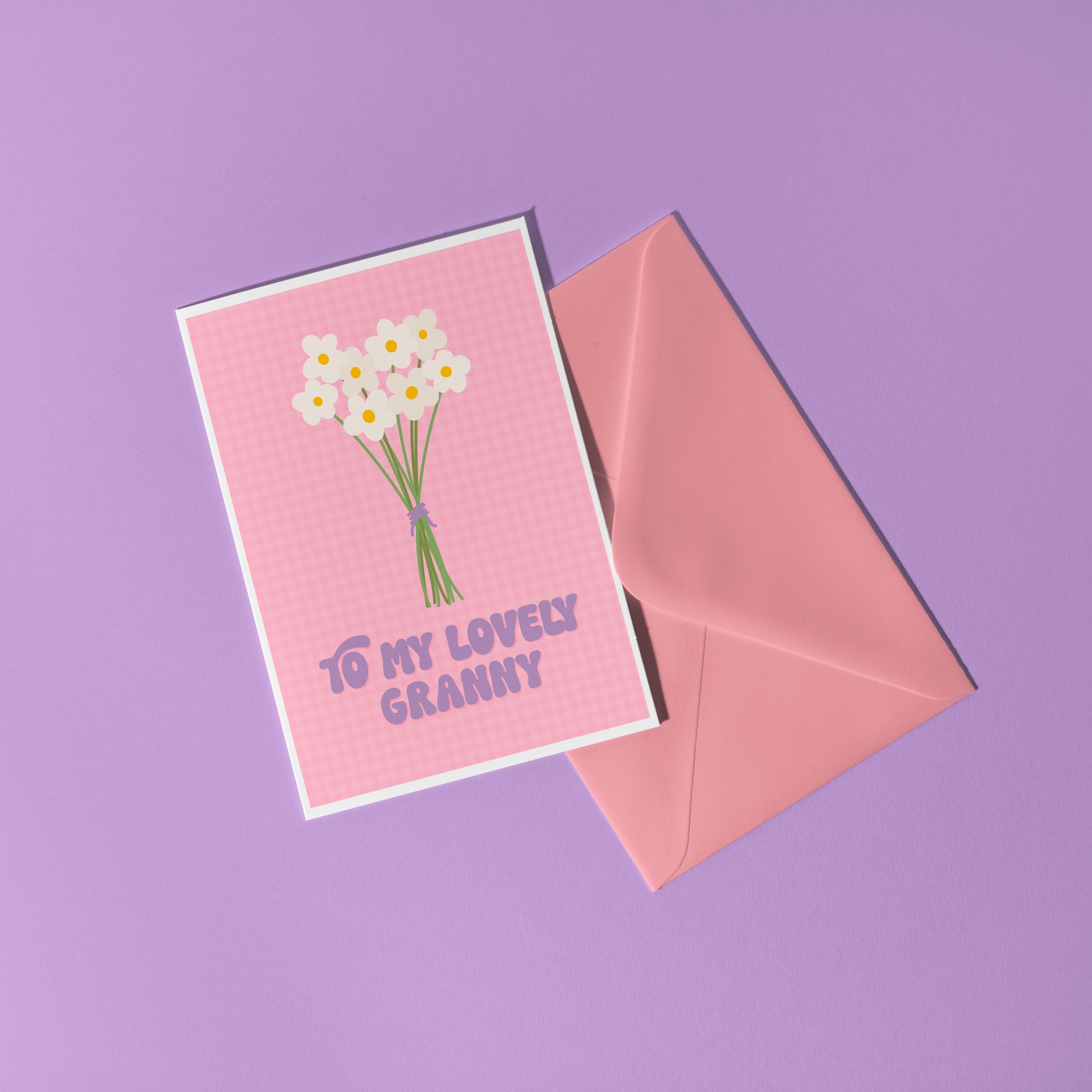 A pink greeting card with the words 'to my lovely Granny' on the front, with a bunch of daisies.