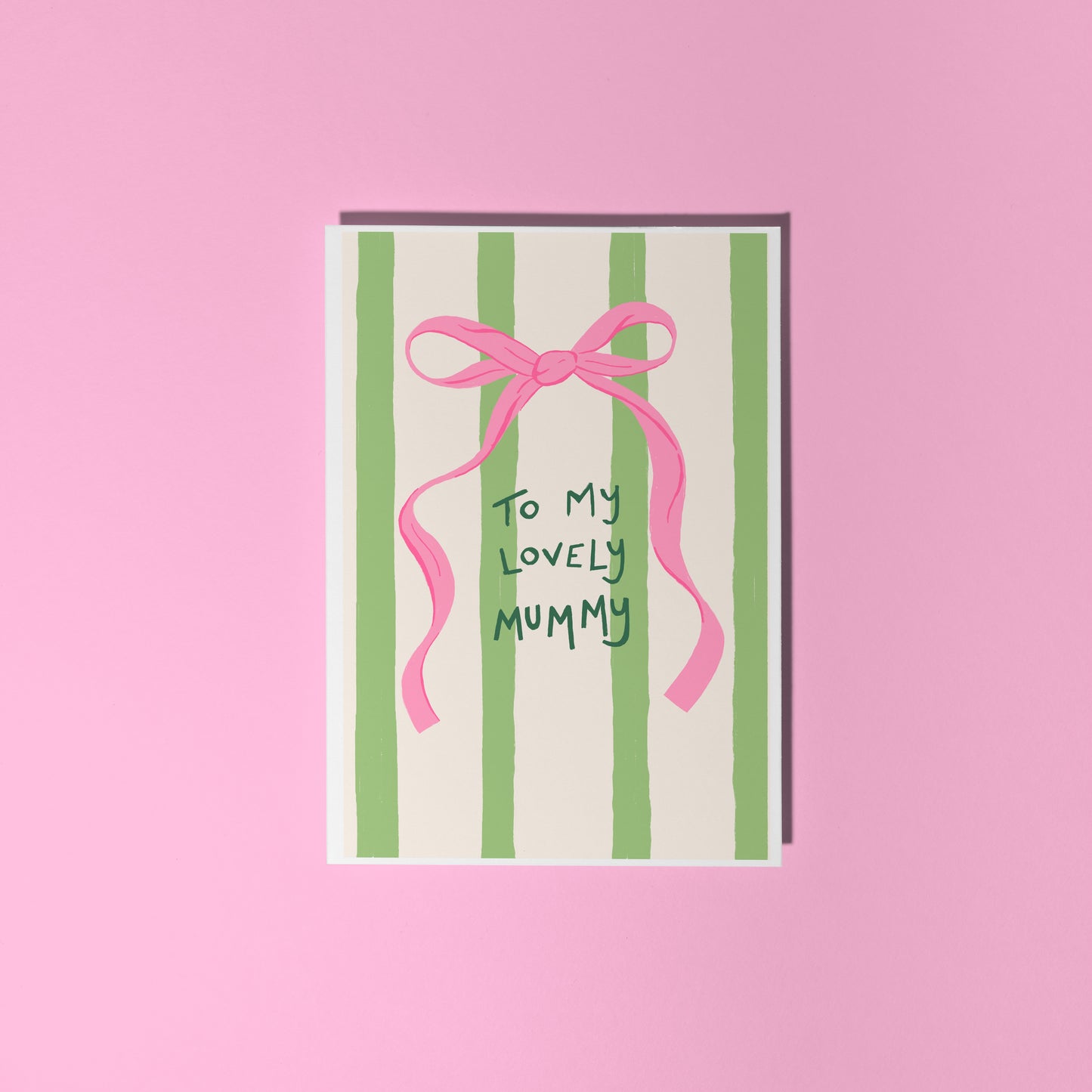 A cream and green striped card, with a pink bow, and handwritten text that says 'to my lovely mummy'.