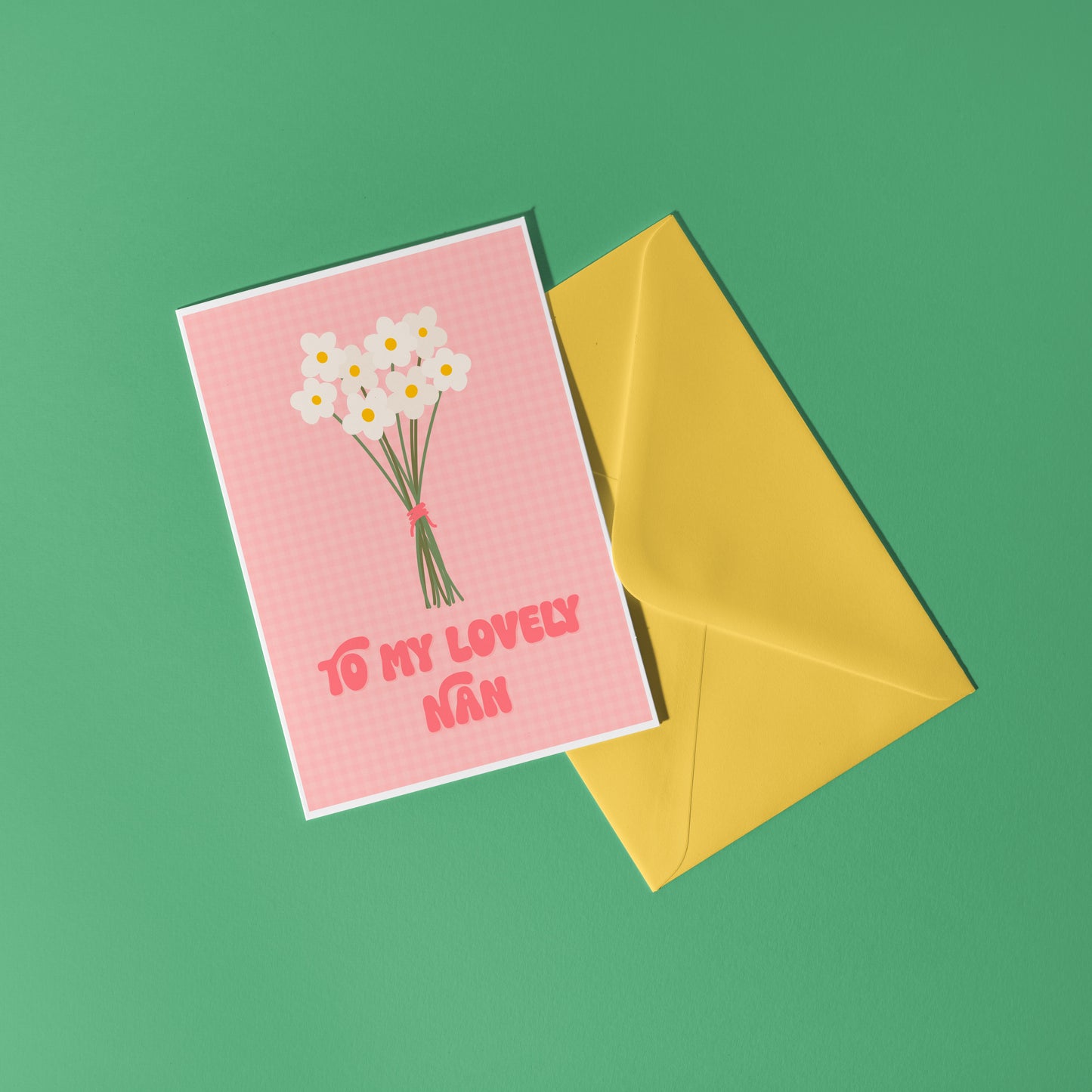 A pink greeting card with the words 'to my lovely nan' on the front, with a bunch of daisies.