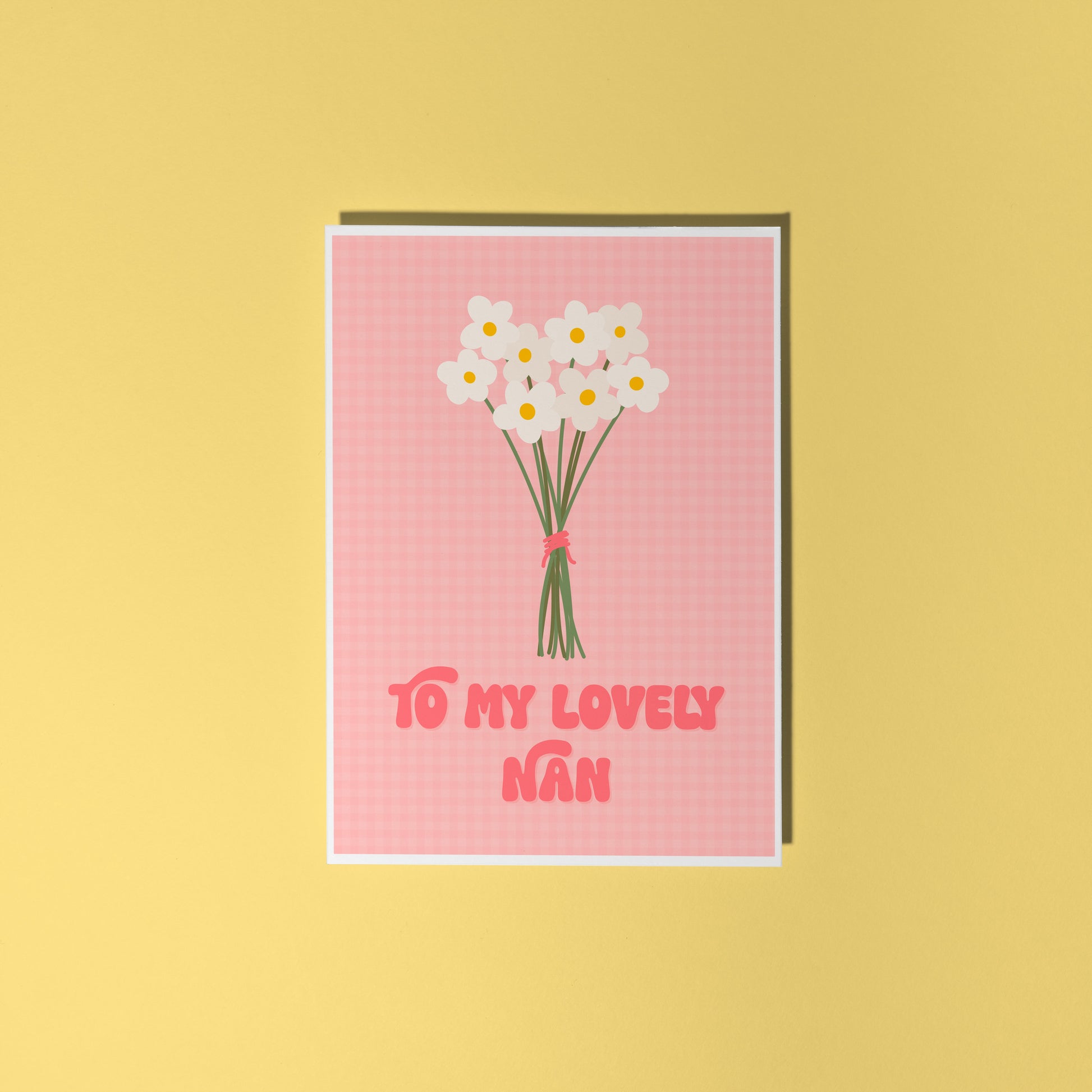 A pink greeting card with the words 'to my lovely nan' on the front, with a bunch of daisies.