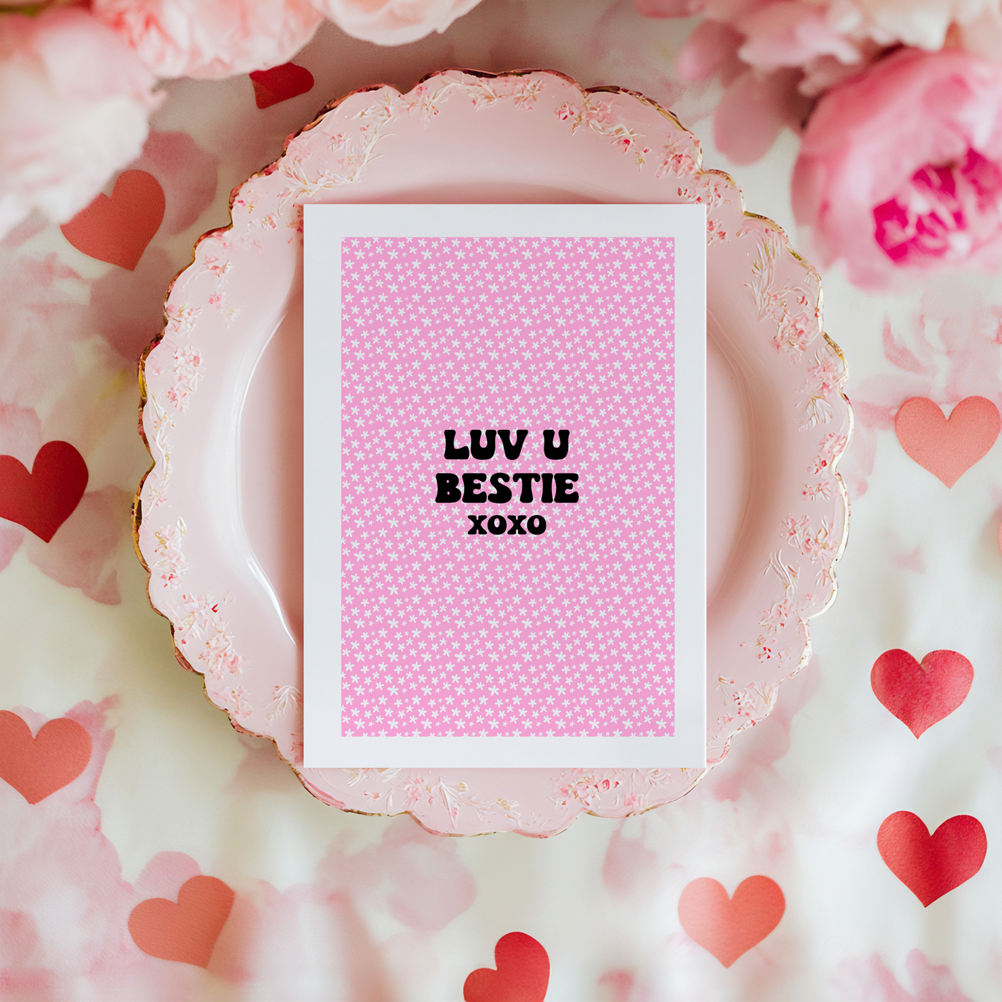 A pink greetings card, with the message 'Luv u bestie xoxo' on the front.