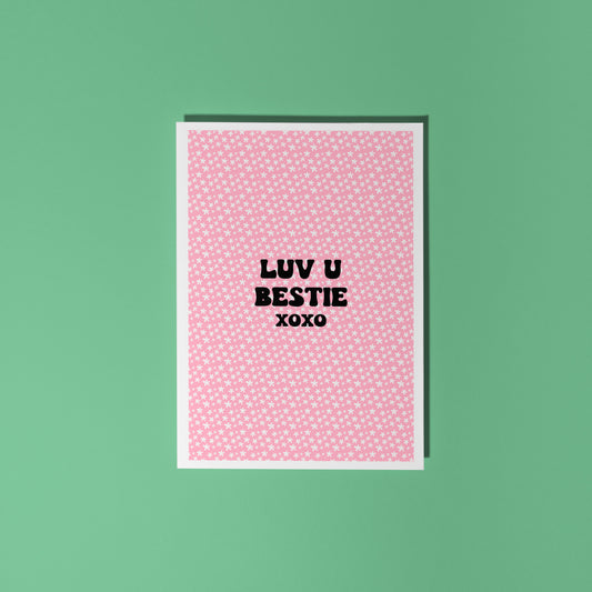 A pink card with little flowers all over, and black writing that says "Luv U Bestie xoxo".
