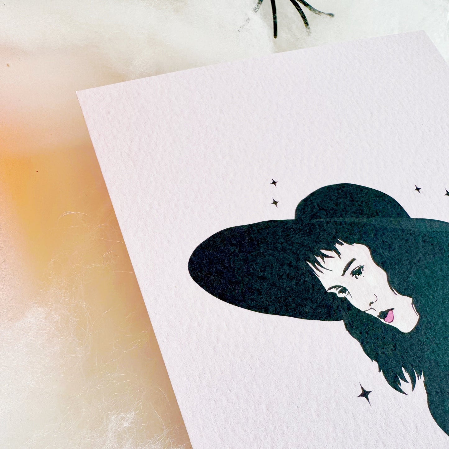 A halloween themed textured postcard with an illustration of Lydia Deetz, from Beetlejuice on the front.