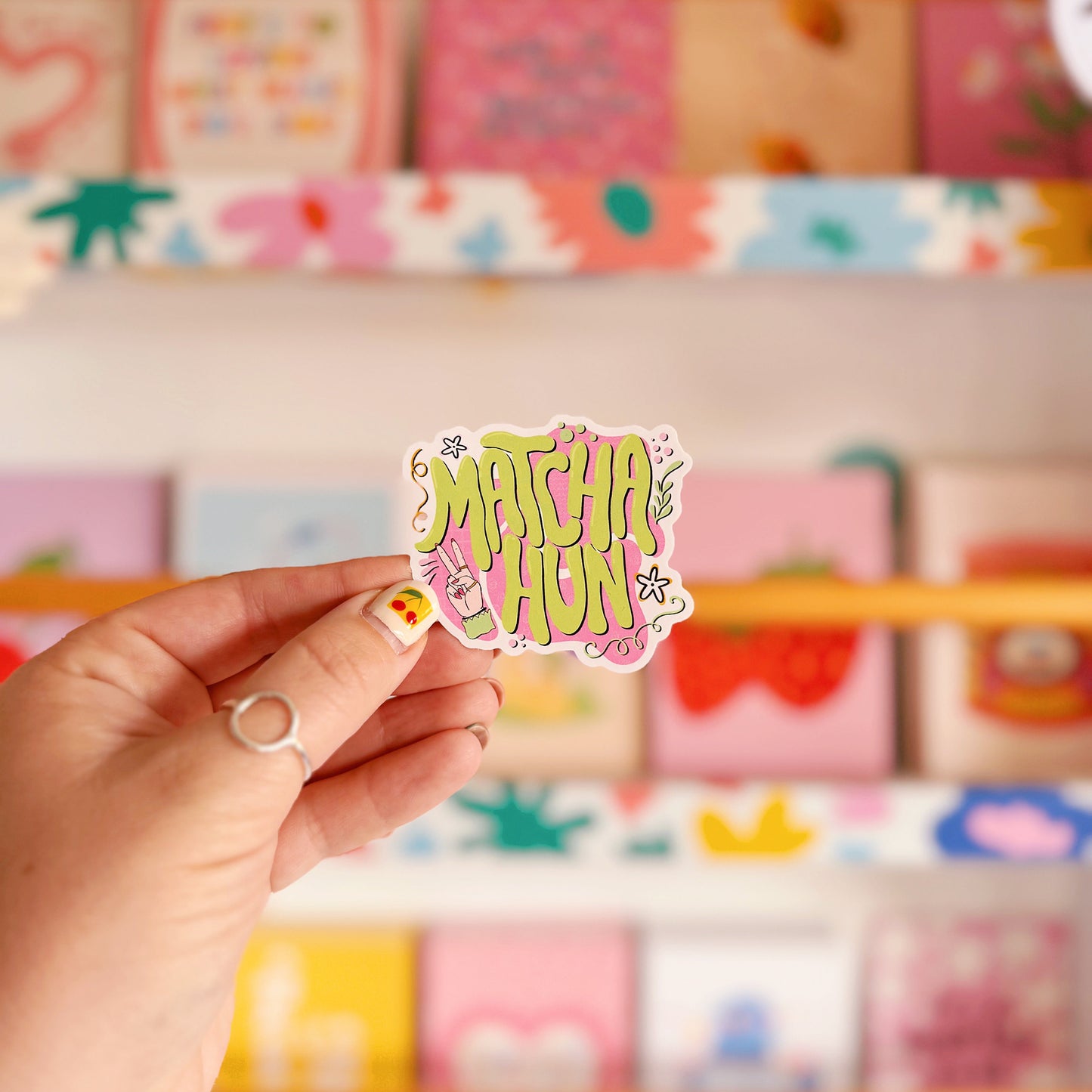 A vinyl sticker which is pink and green and says the words 'Matcha Hun' in fun bubble writing. 