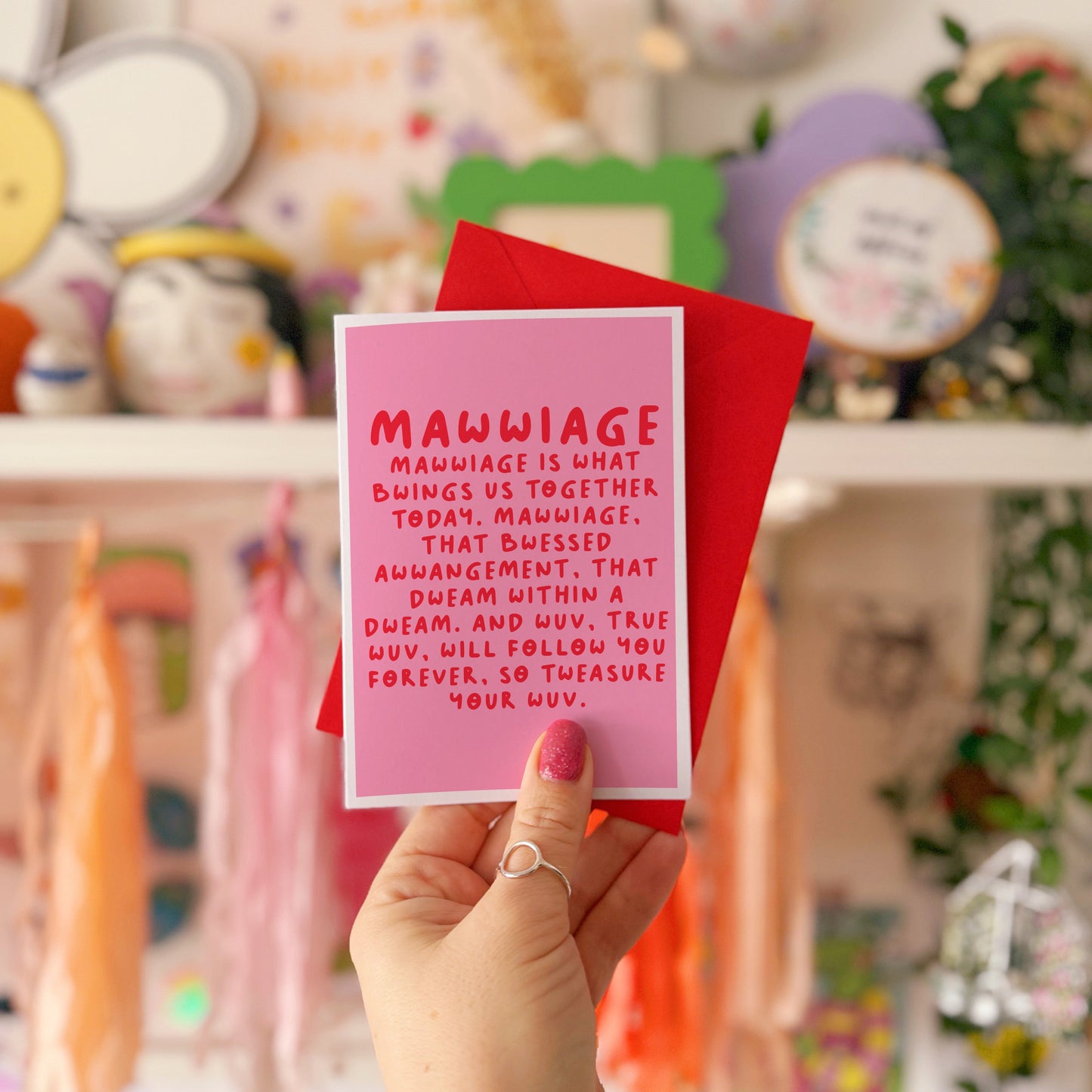 A pink wedding day celebration card, with a quote in red, from the film The Princess Bride.