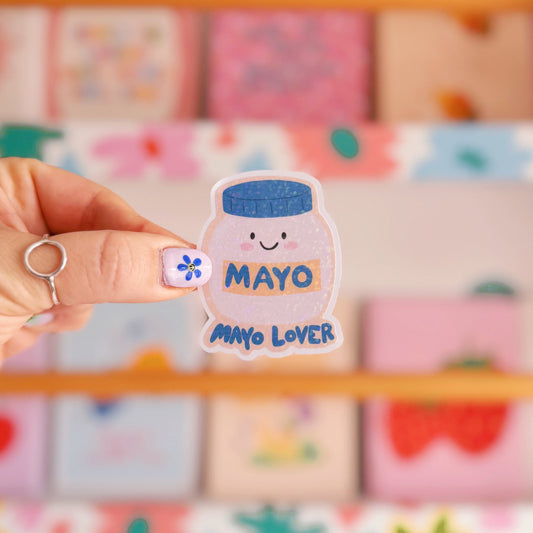 A holographic sticker, with an easy peel lip, featuring an illustration of a jar of mayonnaise. The words 'mayo lover' are underneath in blue.