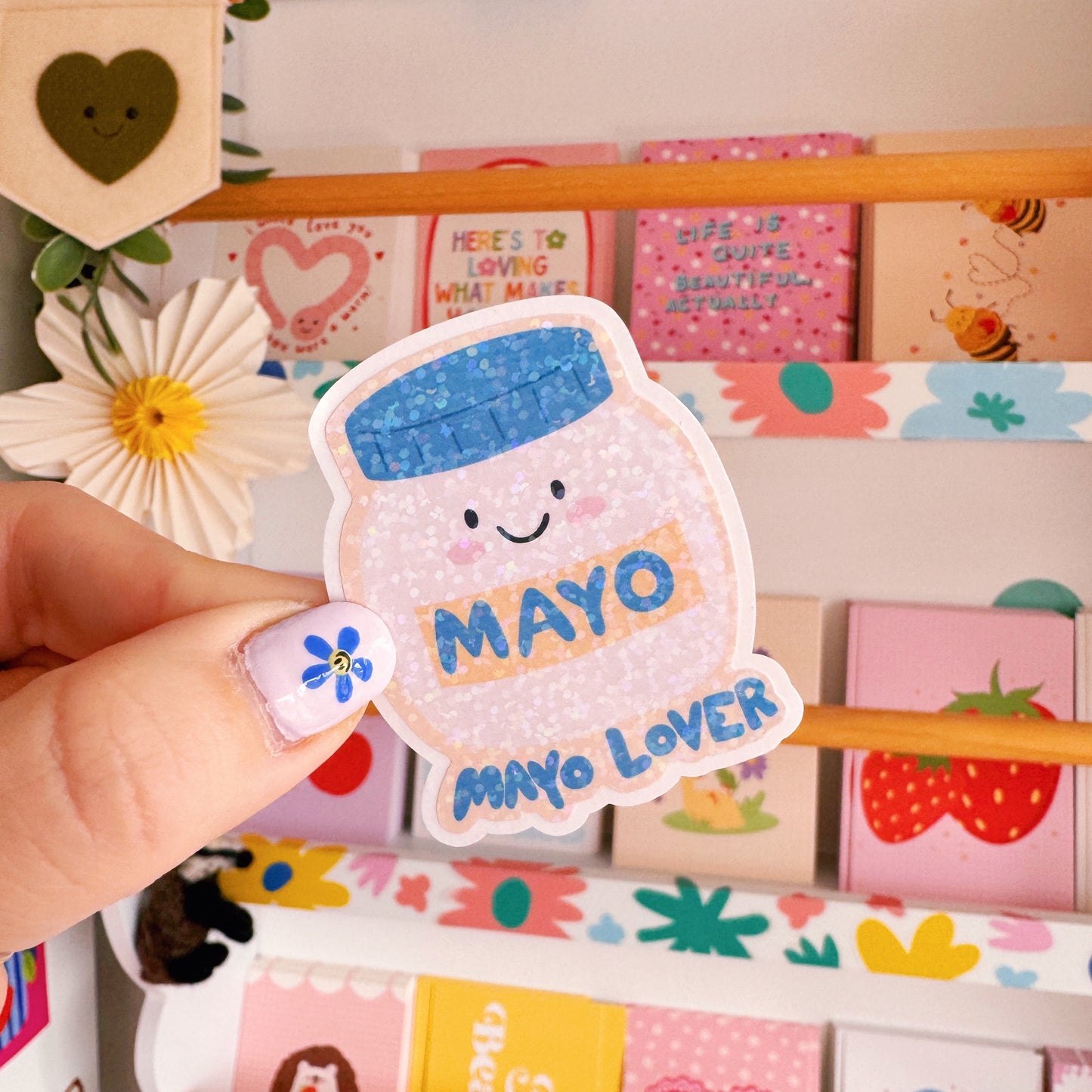 A holographic sticker, with an easy peel lip, featuring an illustration of a jar of mayonnaise. The words 'mayo lover' are underneath in blue.