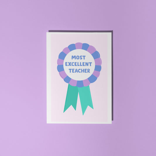 A greetings card with a rosette with text saying most excellent teacher. The colour combo is green blue and purple.