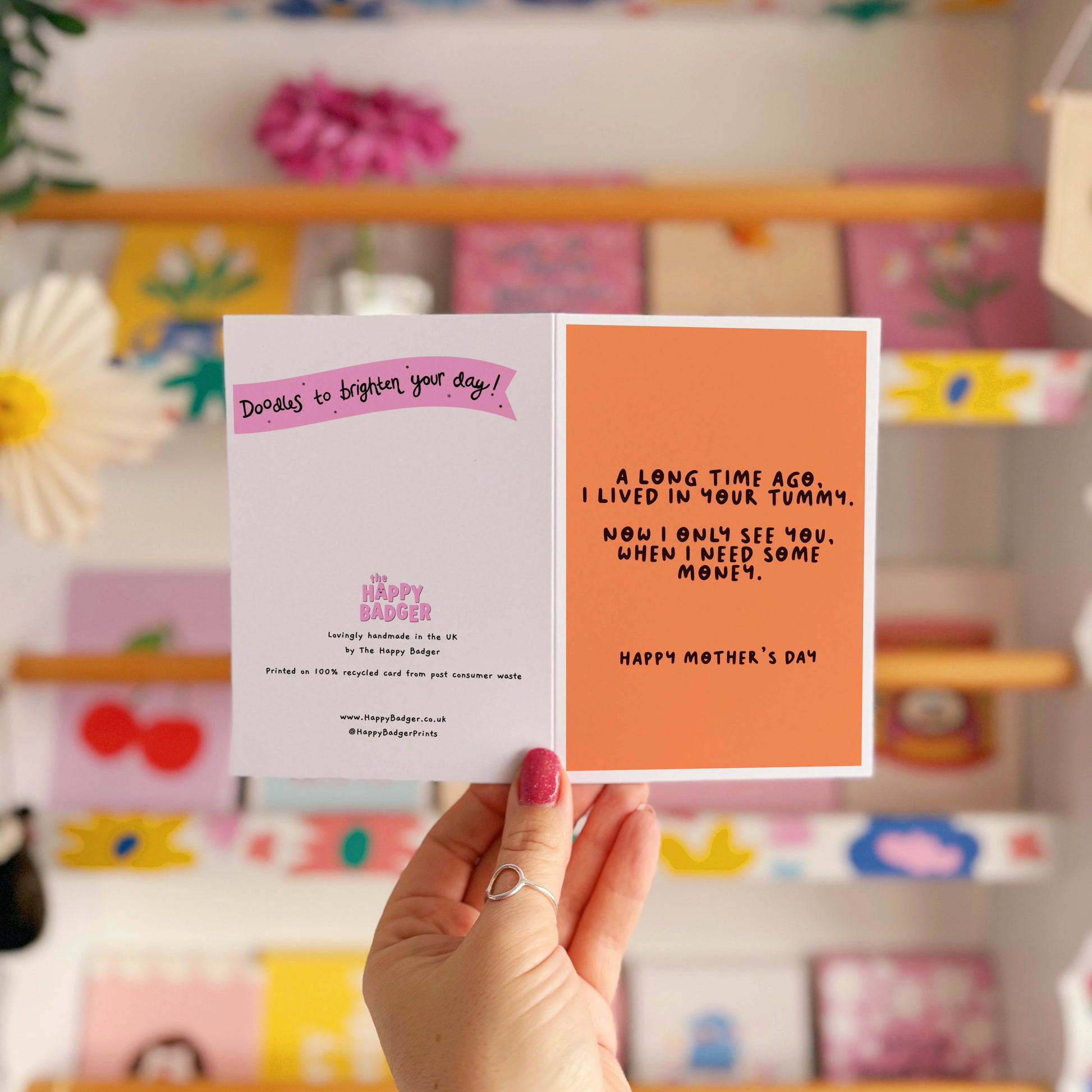An orange Mother's Day card with a funny quote, that says 'A long time ago I lived in your tummy. Now I only see you, when I need some money. Happy Mother's Day".