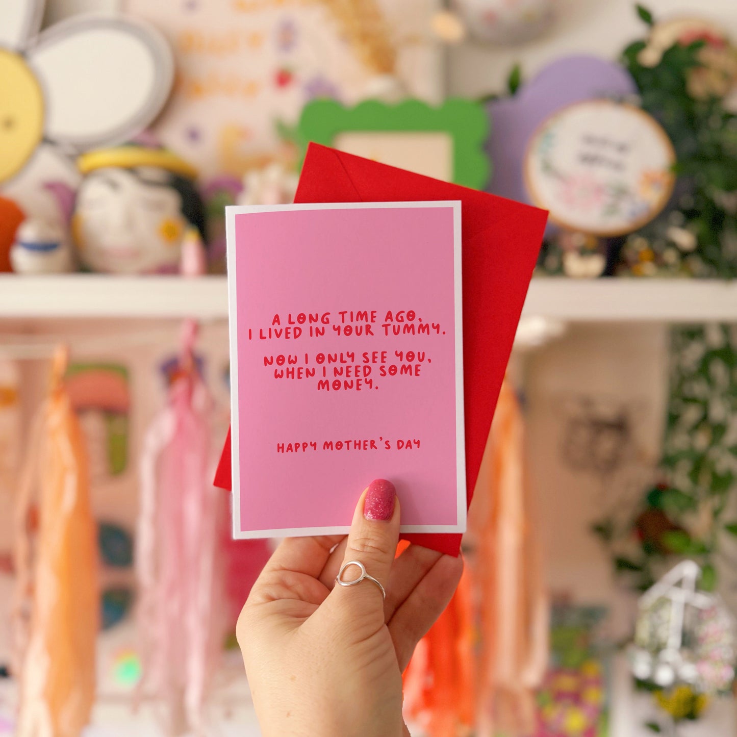 A pink Mother's Day card with a funny quote, that says 'A long time ago I lived in your tummy. Now I only see you, when I need some money. Happy Mother's Day".