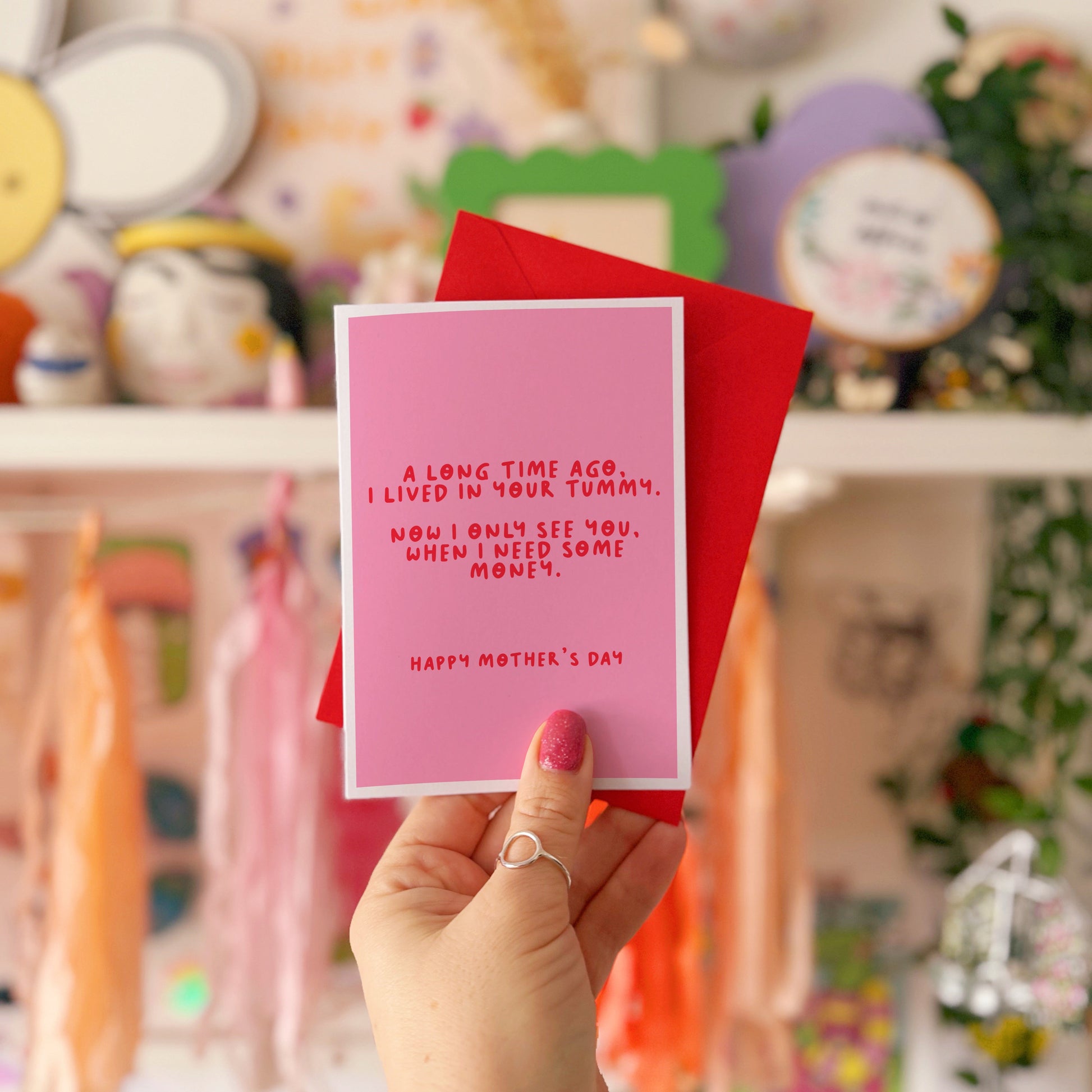A pink Mother's Day card with a funny quote, that says 'A long time ago I lived in your tummy. Now I only see you, when I need some money. Happy Mother's Day".