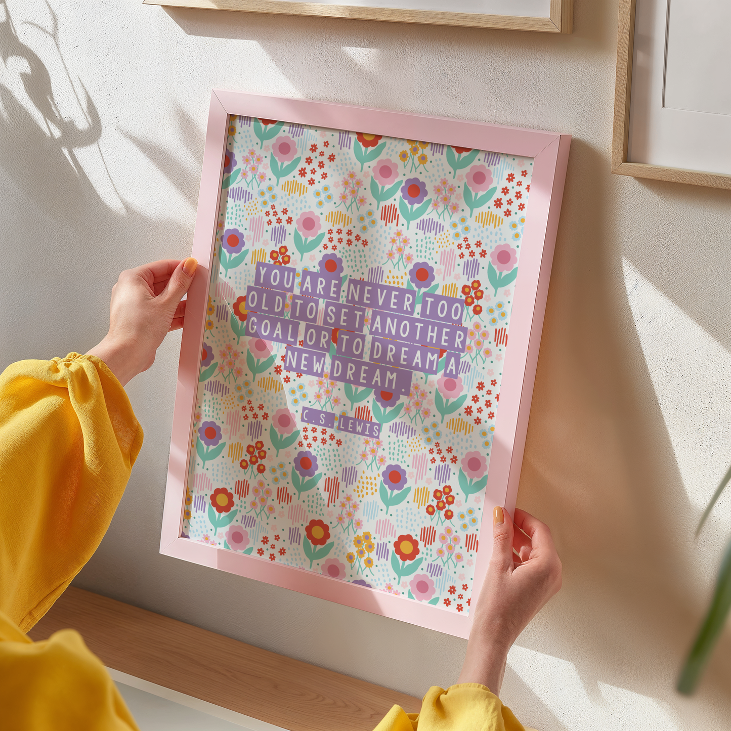 A brightly coloured floral print, with a motivational quote on the front by C.S. Lewis, stating you are never too old to set another goal or to dream a new dream.