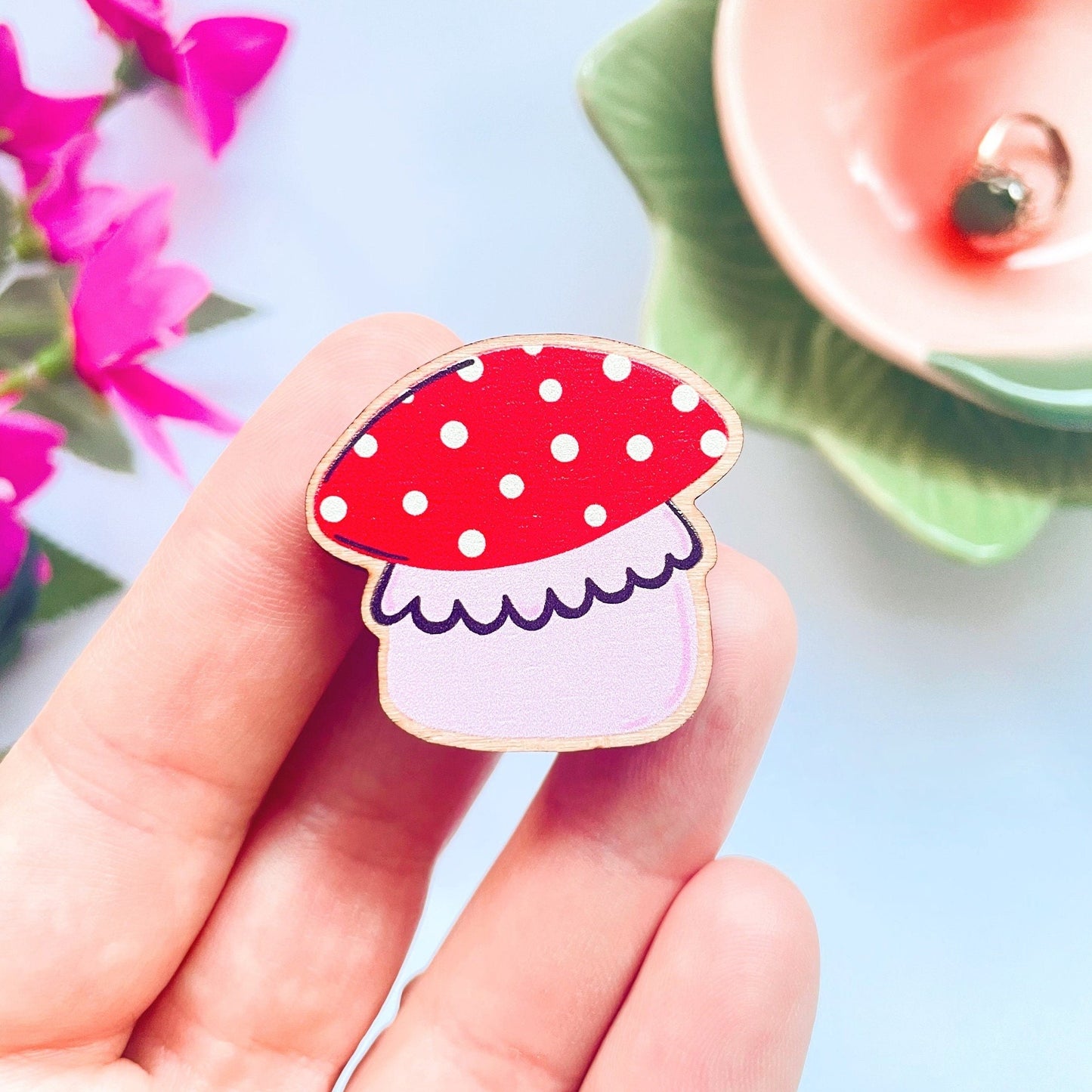 A wooden eco friendly pin badge of a cute chunky mushroom.