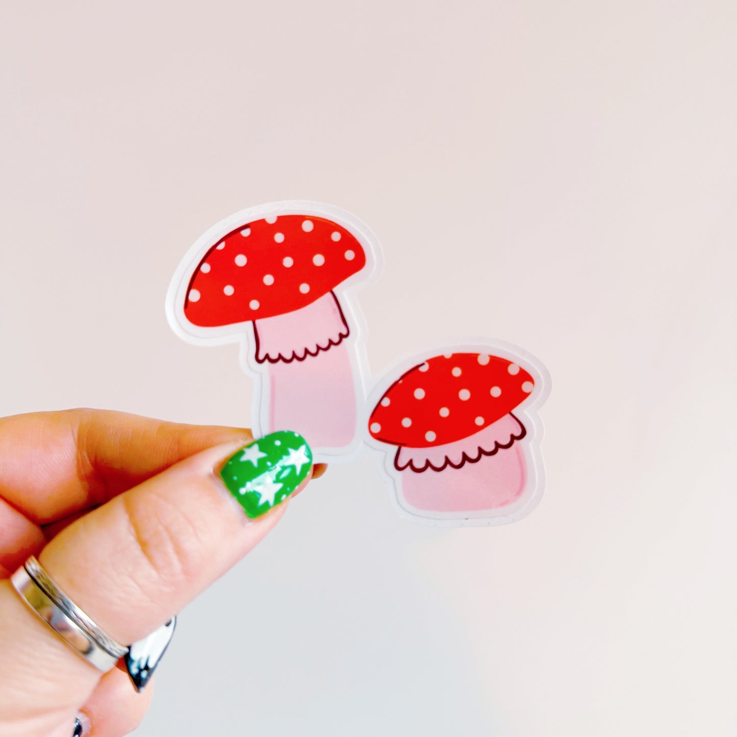 A holographic sticker, of two cute red and pink mushrooms. The sticker has an easy peel lip.