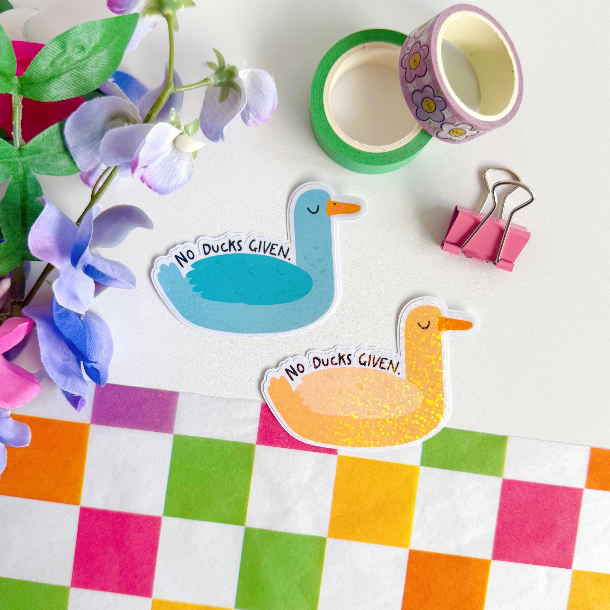 Two cute and funny duck stickers, one blue and one yellow, with the words 'no ducks given' above their wings. They have a glittery effect to the stickers.