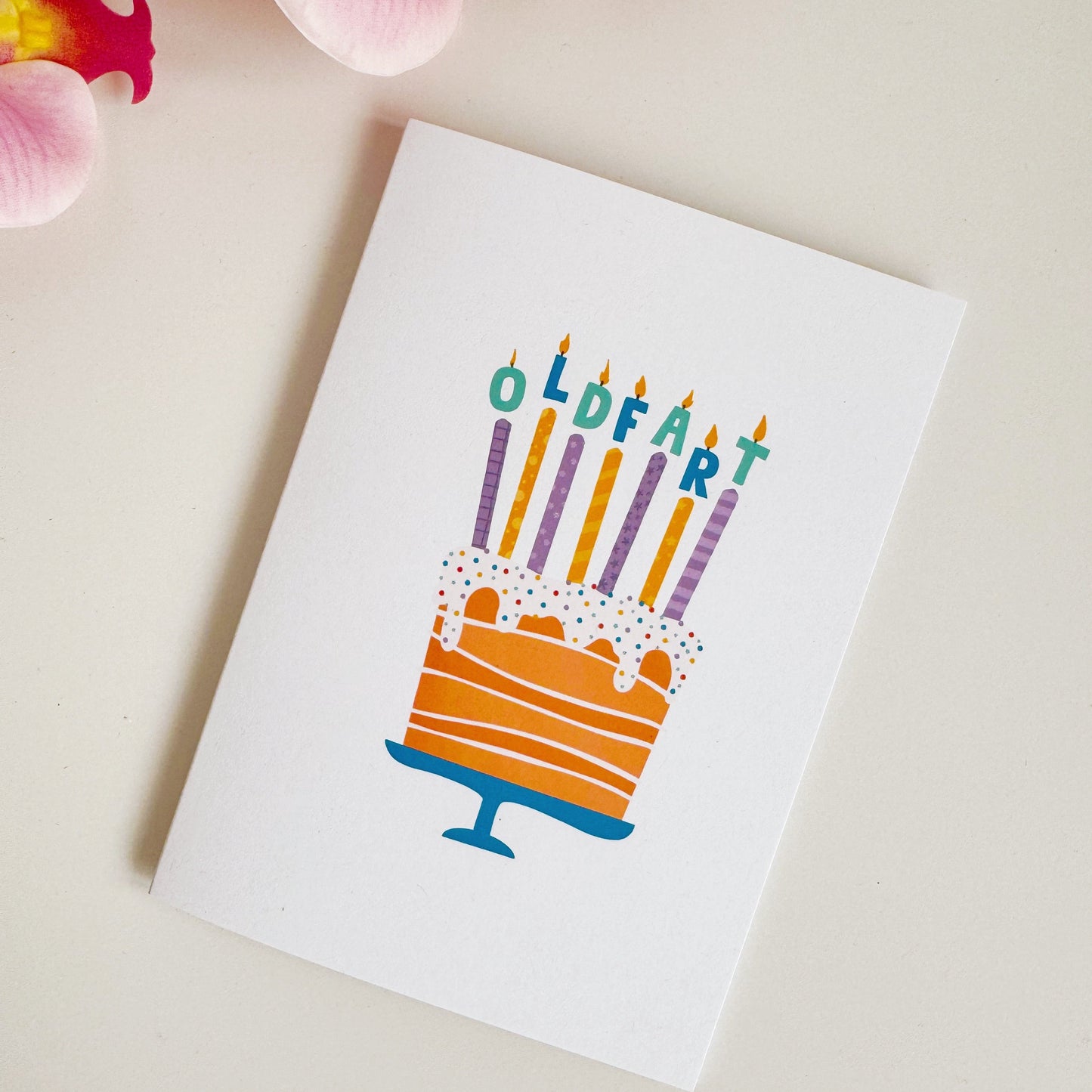 A card with a cake and candles, with each of the candles having the letters to the phrase 'old fart' spelt out.