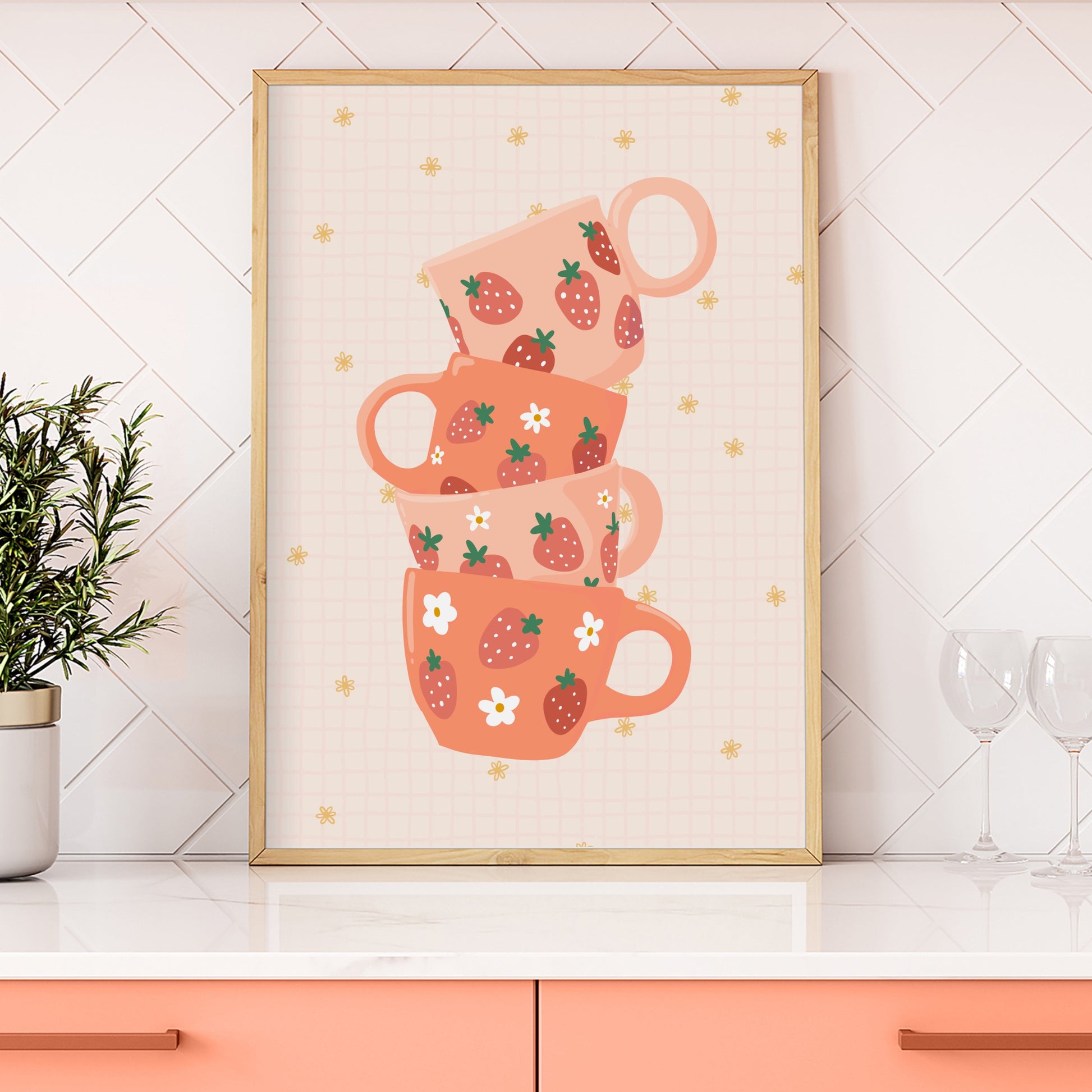 A stack of pink and orange mugs with strawberries on them, on a warm pale orange background.