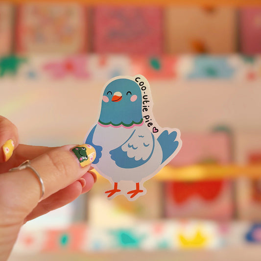 A waterproof vinyl sticker featuring an illustration of a pigeon and text that reads 'coo-utie pie'