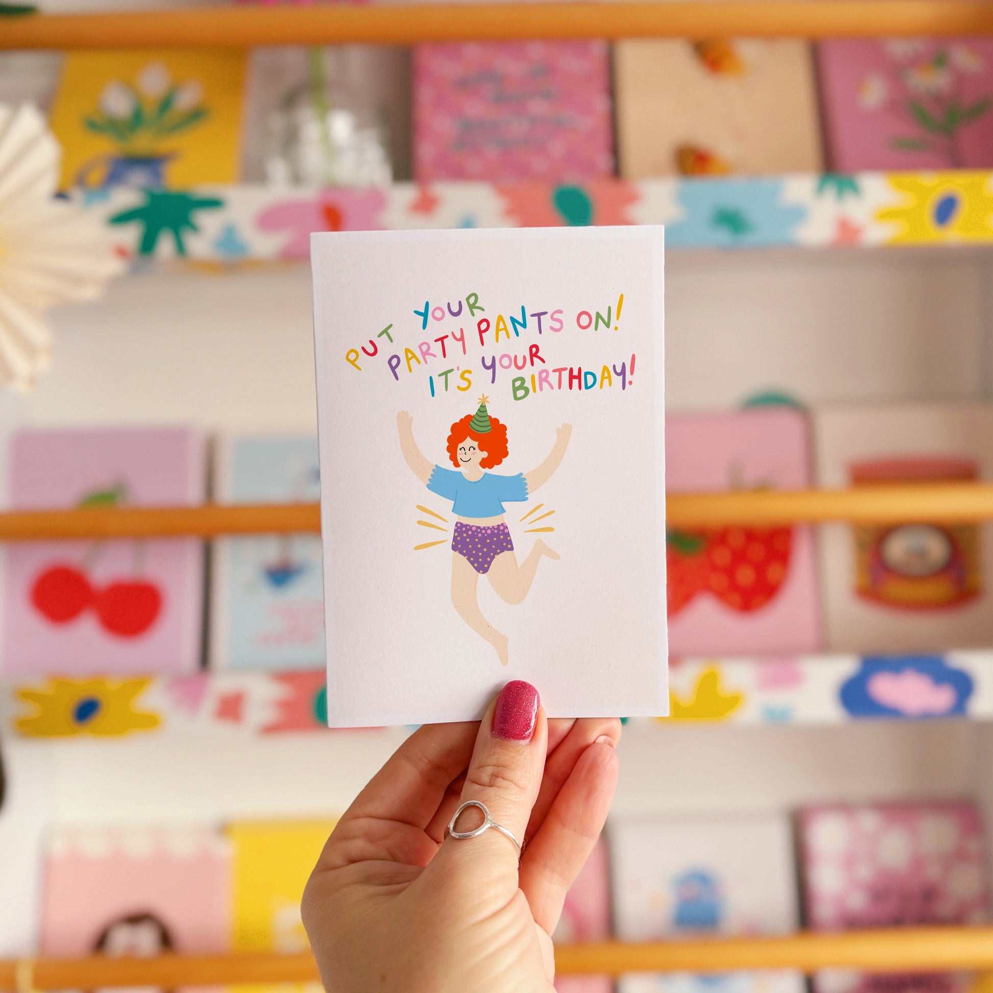 A colourful birthday card with a person jumping for joy wearing their underwear, with text that reads 'put your party pants on! it's your birthday!'