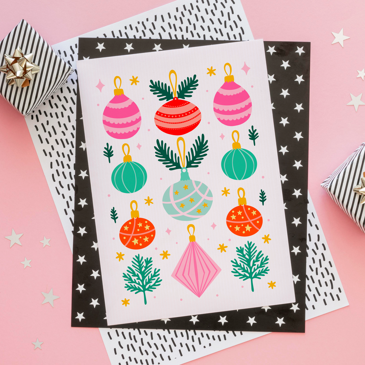 An illustrated Christmas print with 9 brightly coloured baubles, with sprigs of pine decorating the page.