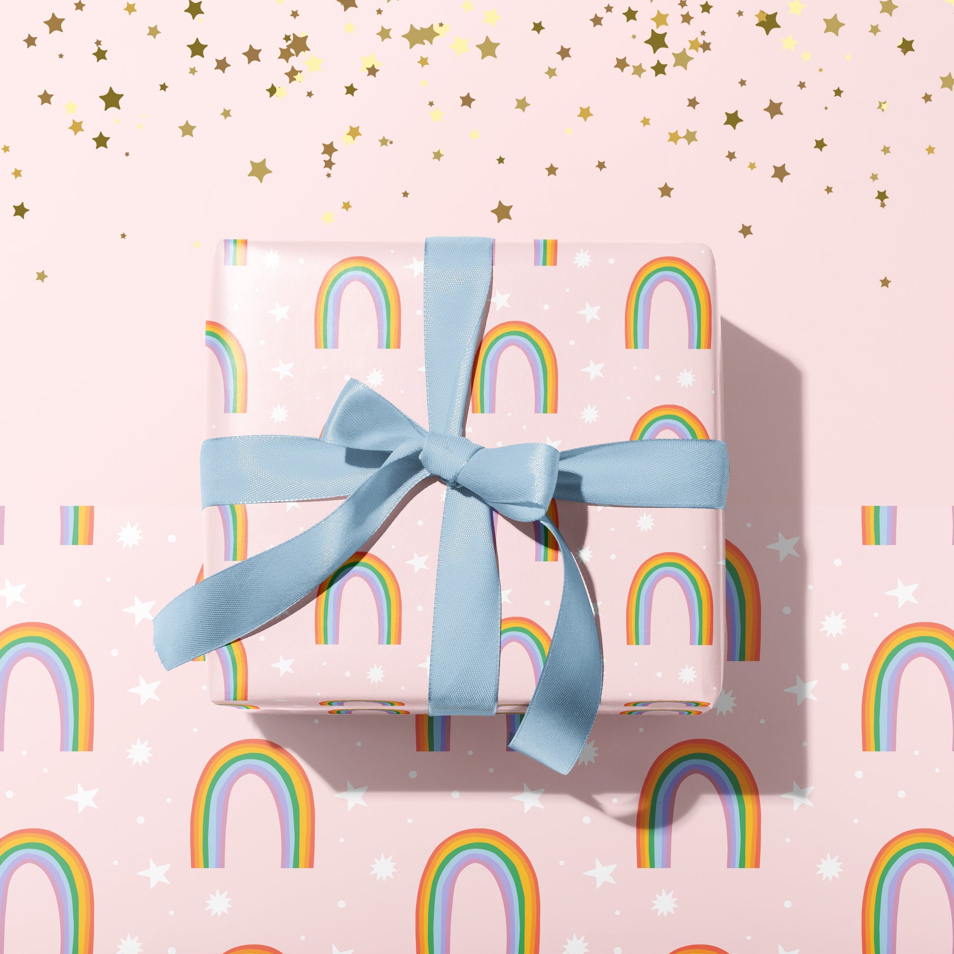 A gift wrapped present, wrapped up in a pastel rainbow print gift wrap from The Happy Badger.