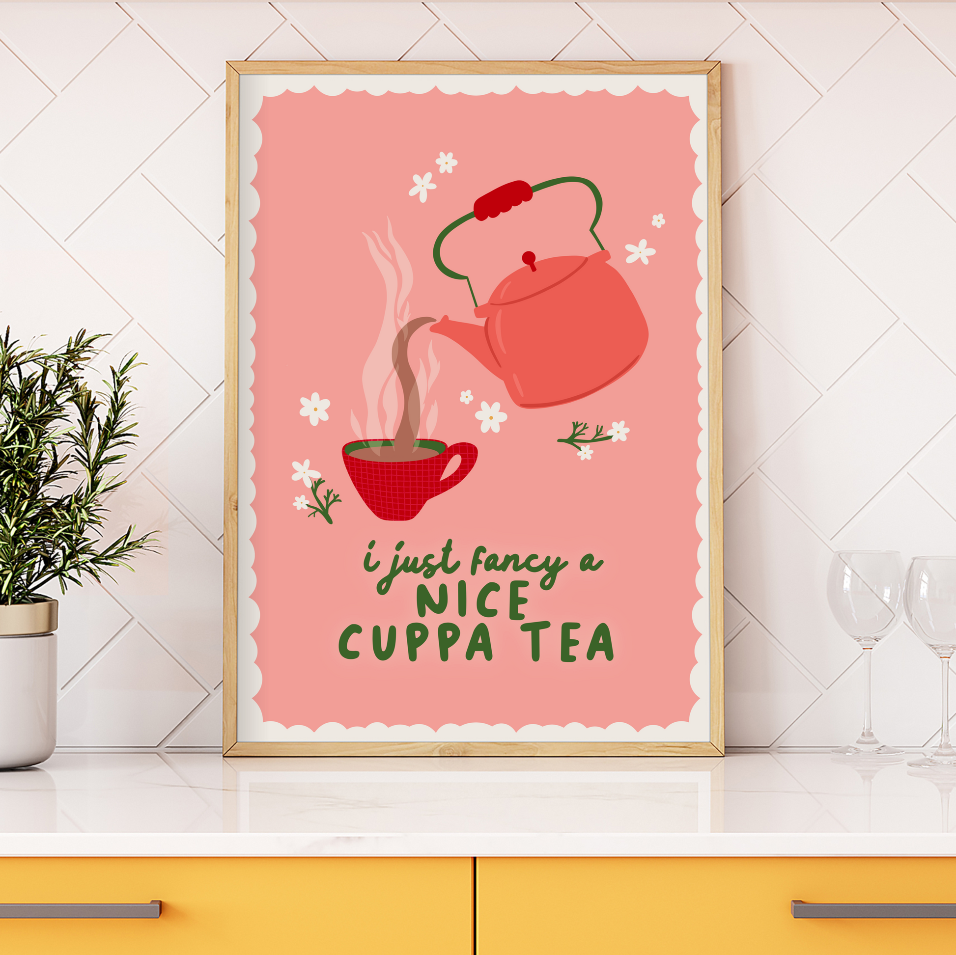 A print with a pink background, with a beige scalloped border, with an illustration of a vintage style kettle and a mug of tea. the quote at the bottom reads 'I just fancy a nice cuppa tea'