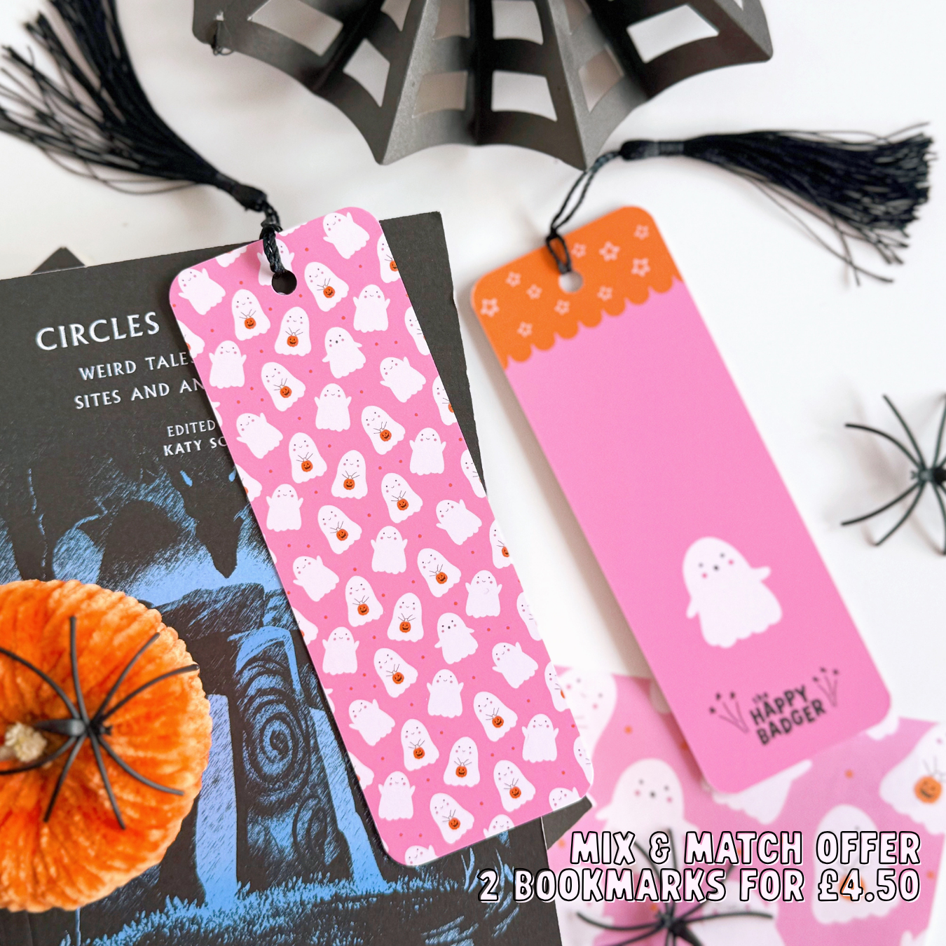 A pink bookmark with little cute ghosts all over it, and a coordinating black tassel.