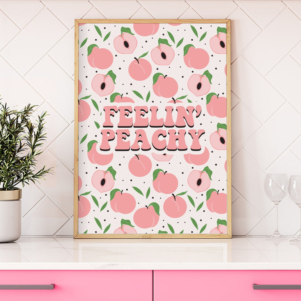 A print featuring a peach repeating pattern, and coordinating lettering saying 'Feelin' Peachy' in the centre.