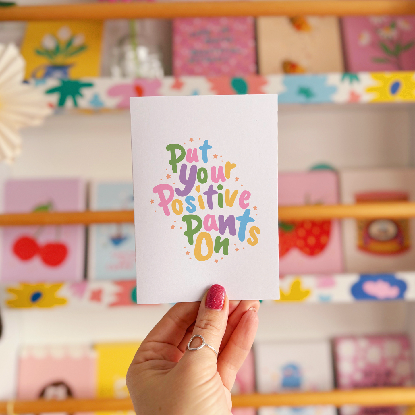 A card with a colourful quote on that reads 'put your positive pants on'.