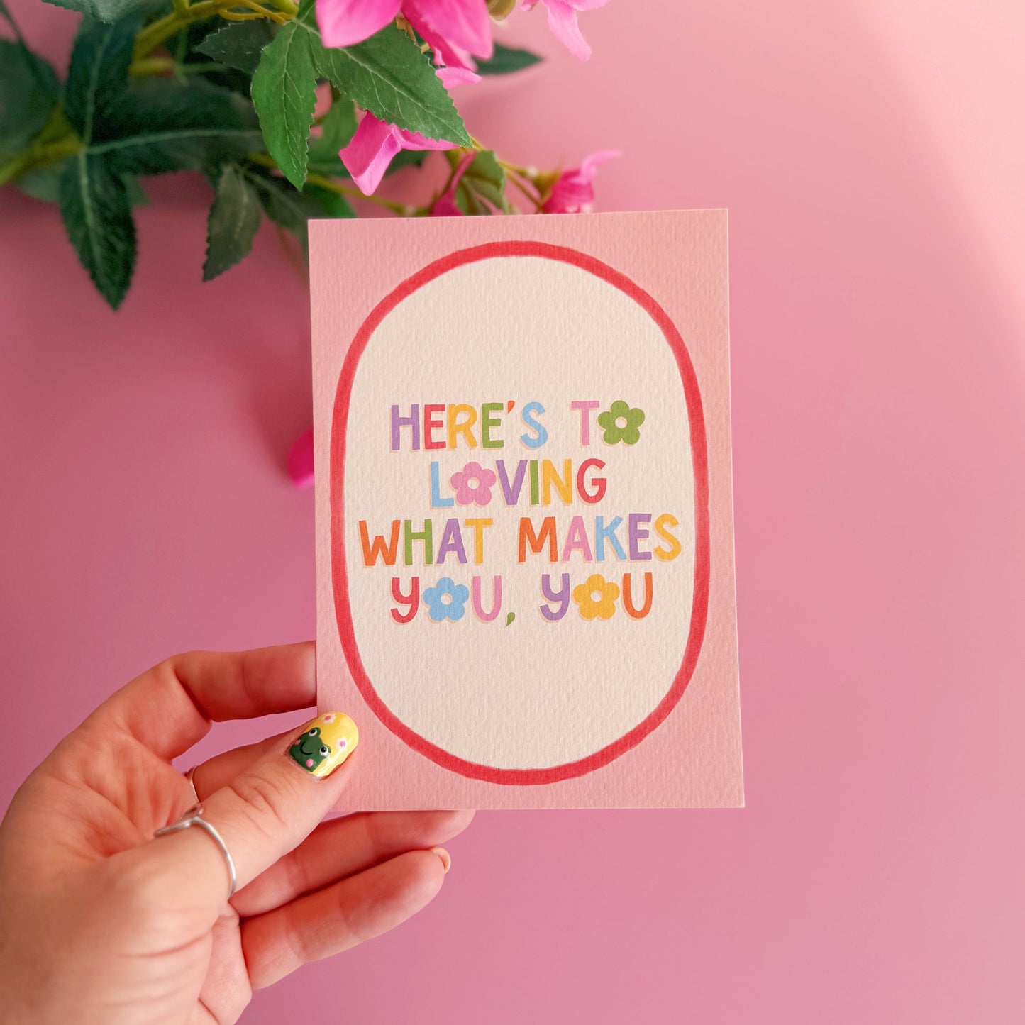 A pink postcard with a colourful positive quote on. 