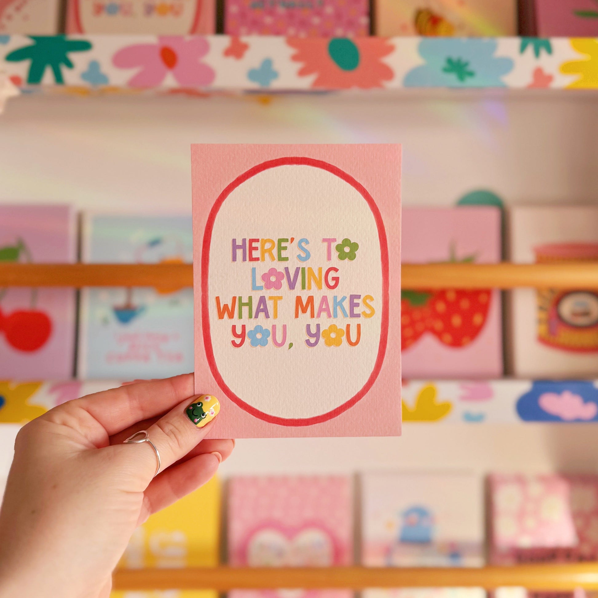 A pink postcard with a colourful positive quote on. 