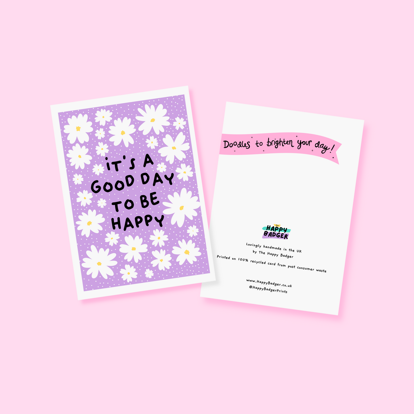 A purple card, with daisies, and the message 'it's a good day to be happy' in the centre. 