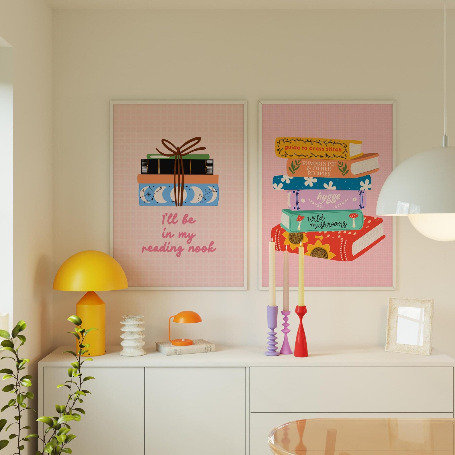 Two framed illustrations on a wall above a white cabinet with decorative items.