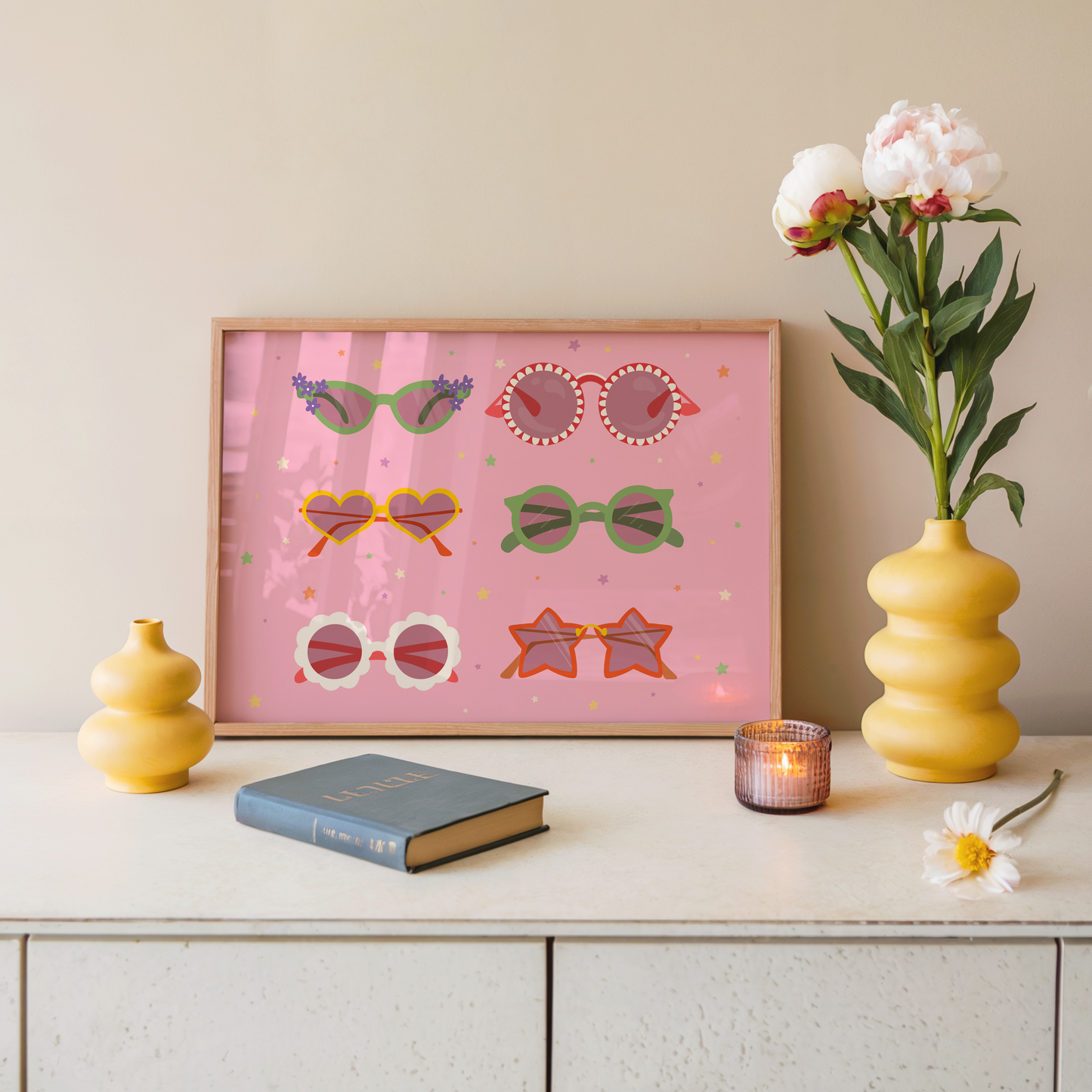 A pink print, with 6 pairs of different colourful sunglasses illustrated, in all different shapes. The background of the print is decorated with little colourful star illustrations.