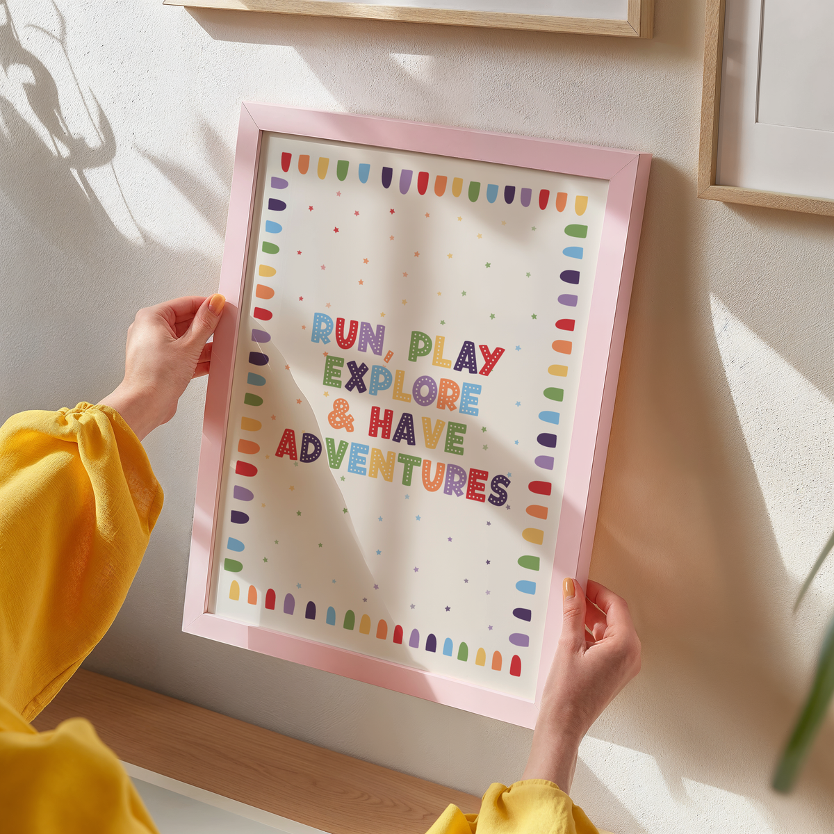 An art print with colourful text reading 'RUN, PLAY, EXPLORE & HAVE ADVENTURES'.