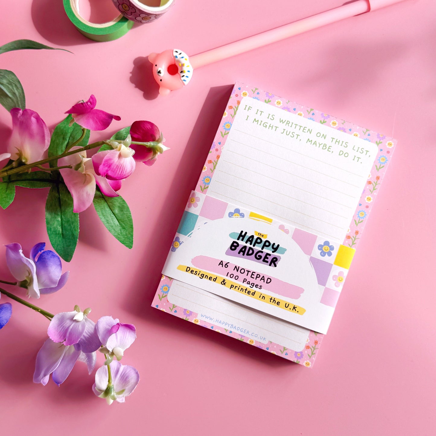 Notebook with flowers and stationery on a pink background