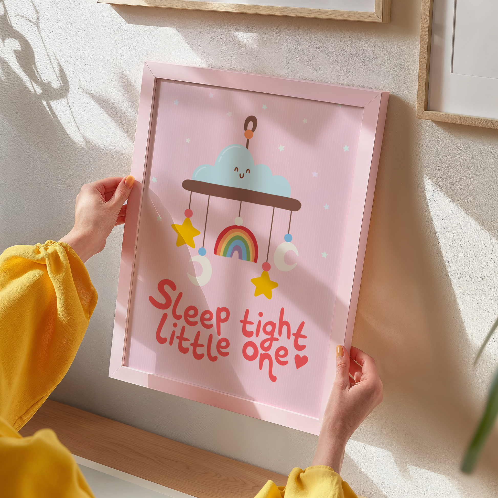 A pink print with an illustration of a children's mobile, and the words 'sleep tight little one' underneath.