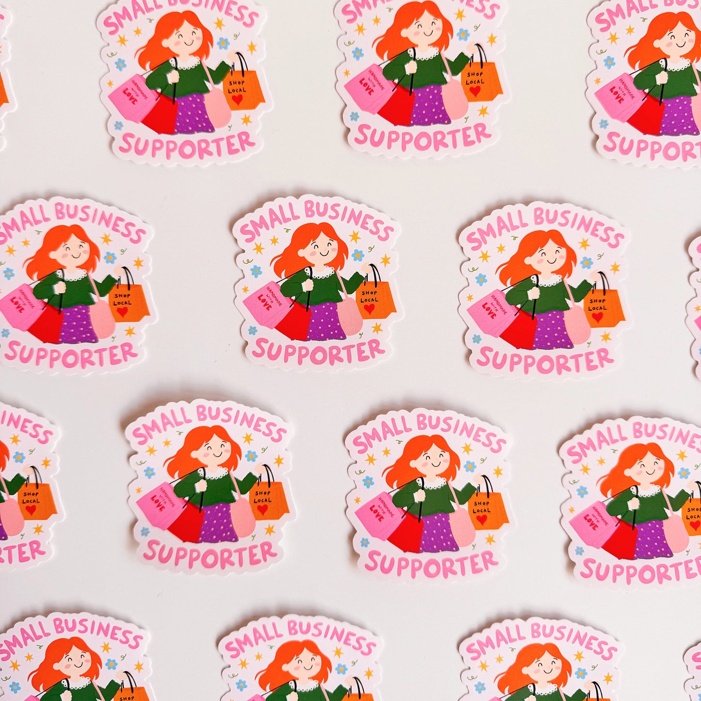A vinyl sticker with n illustration of a girl holding shopping bags and text that reads 'Small Business Supporter'.
