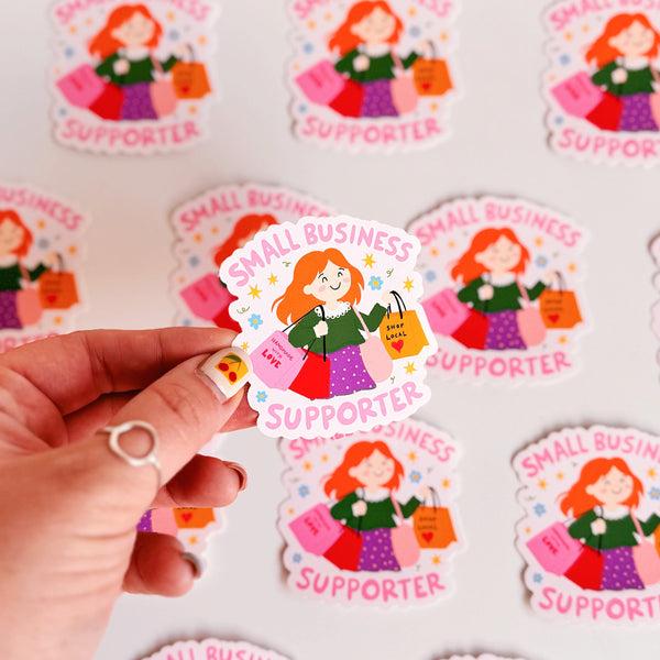 A vinyl sticker with n illustration of a girl holding shopping bags and text that reads 'Small Business Supporter'.