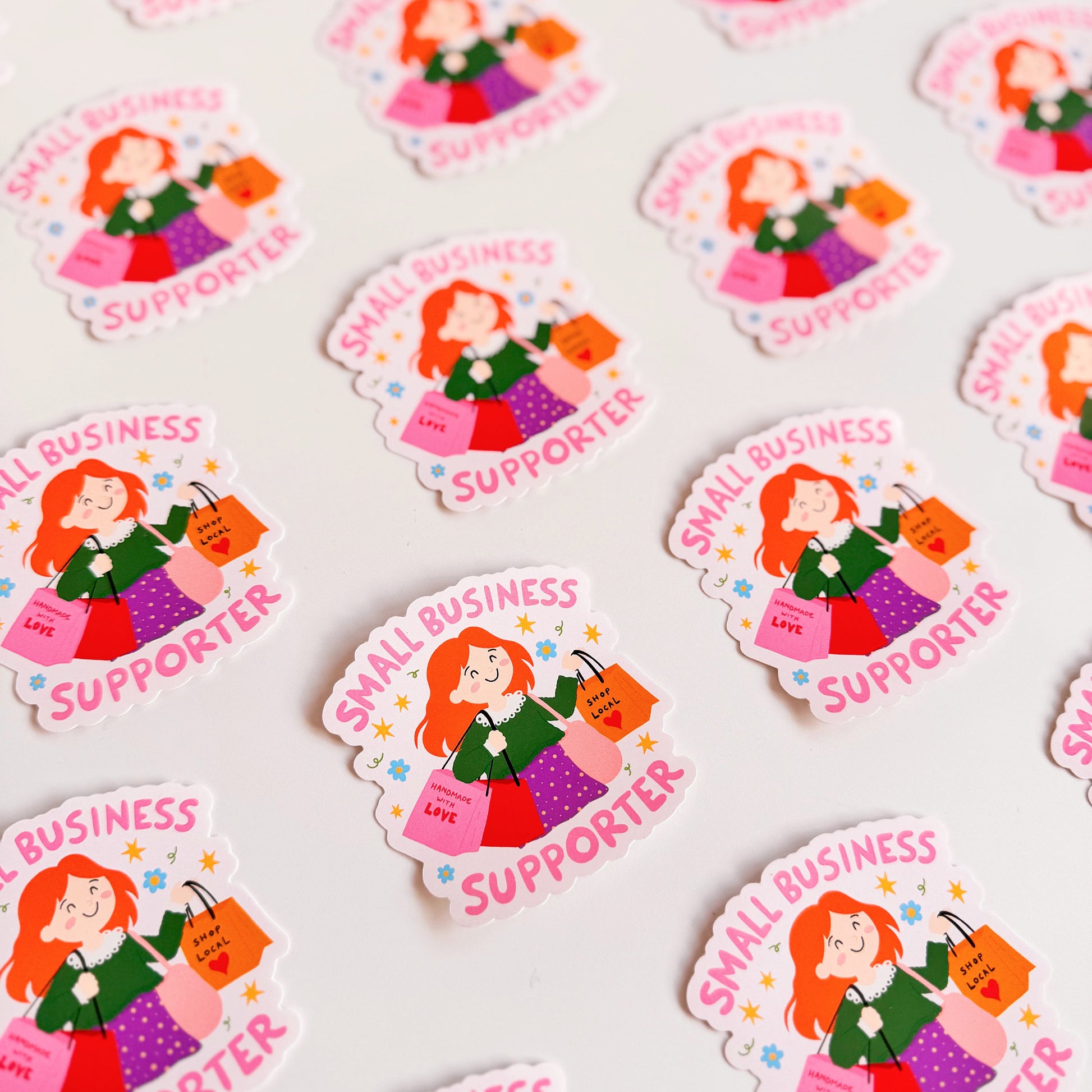 A vinyl sticker with n illustration of a girl holding shopping bags and text that reads 'Small Business Supporter'.