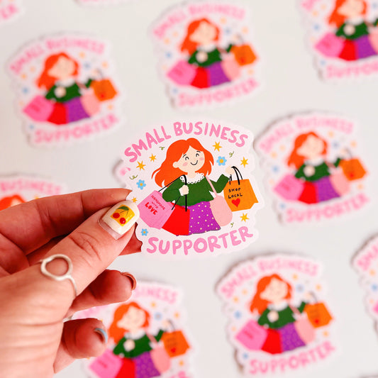 A vinyl sticker with n illustration of a girl holding shopping bags and text that reads 'Small Business Supporter'.