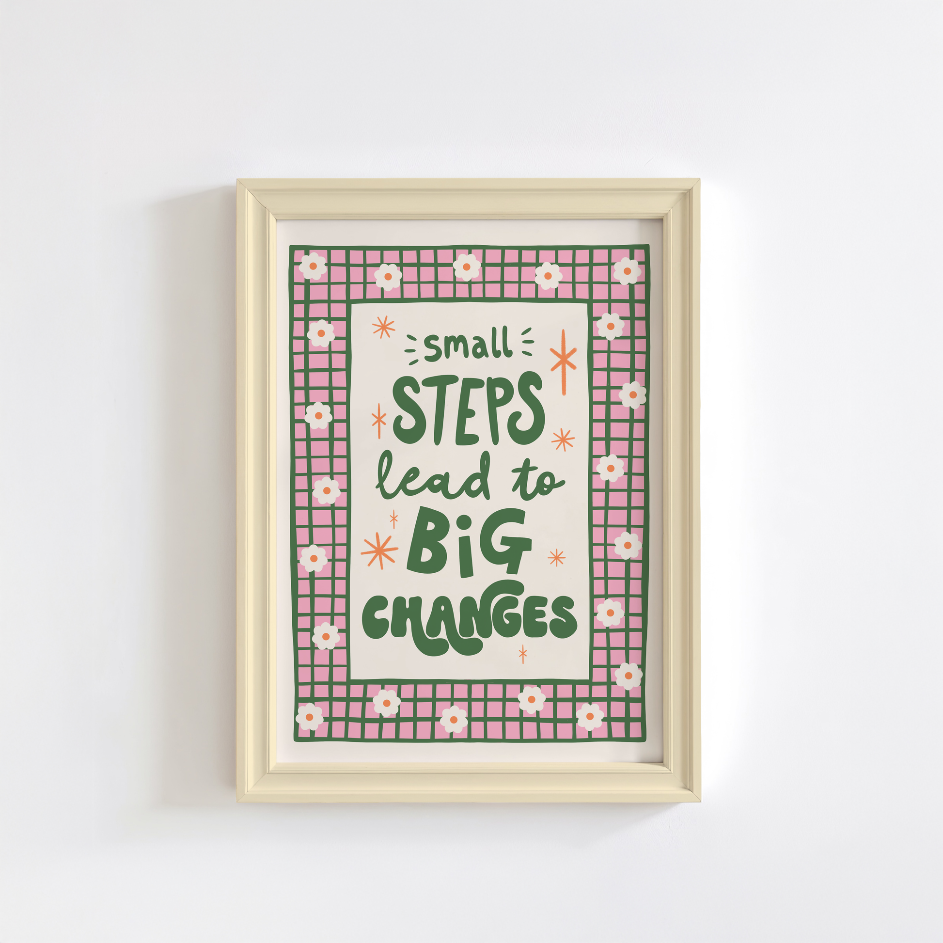 A positive quote print that reads 'small steps lead to big changes' in green hand writing. Around the quote is a hand drawn pink and green checkered border with daisy doodles.