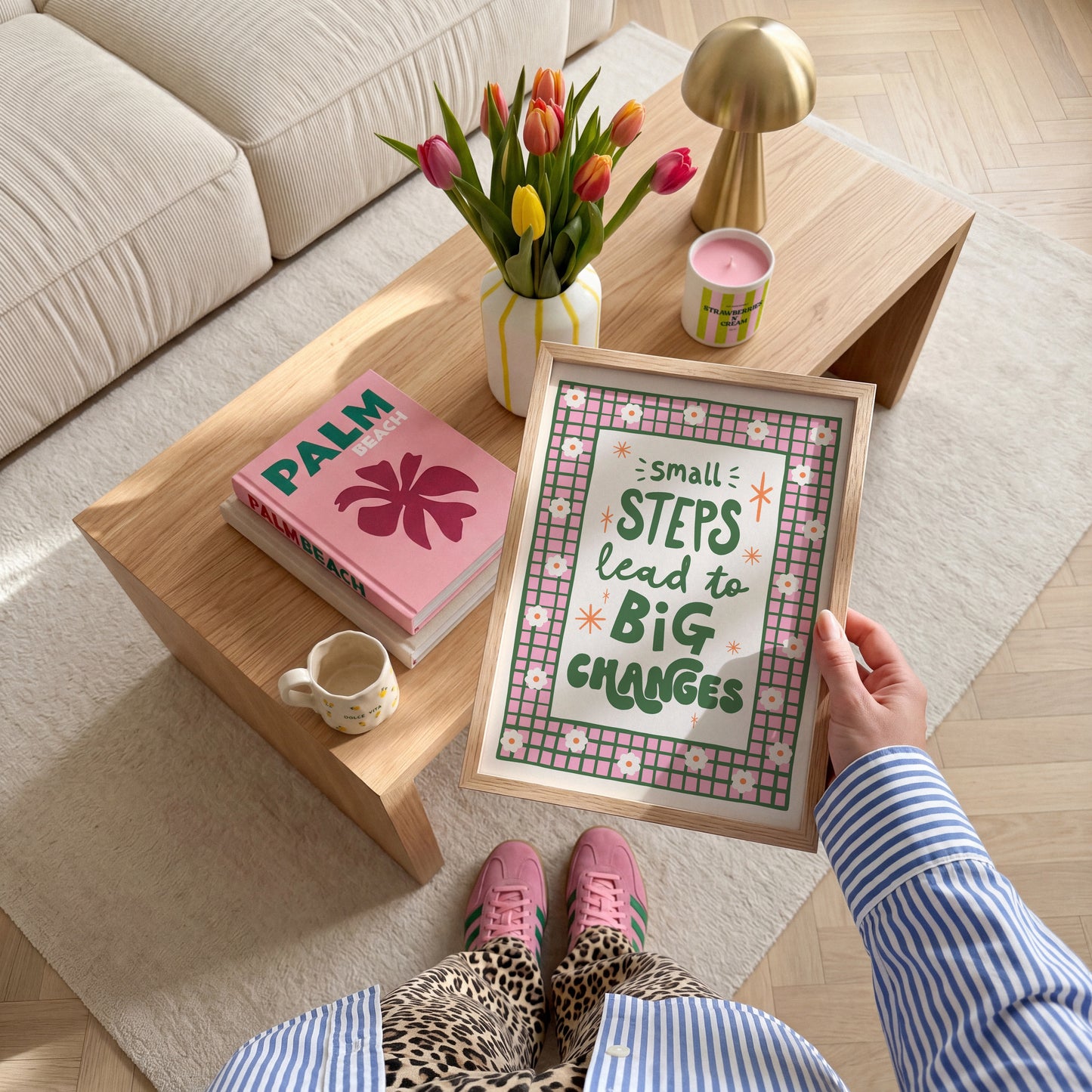 A positive quote print that reads 'small steps lead to big changes' in green hand writing. Around the quote is a hand drawn pink and green checkered border with daisy doodles.