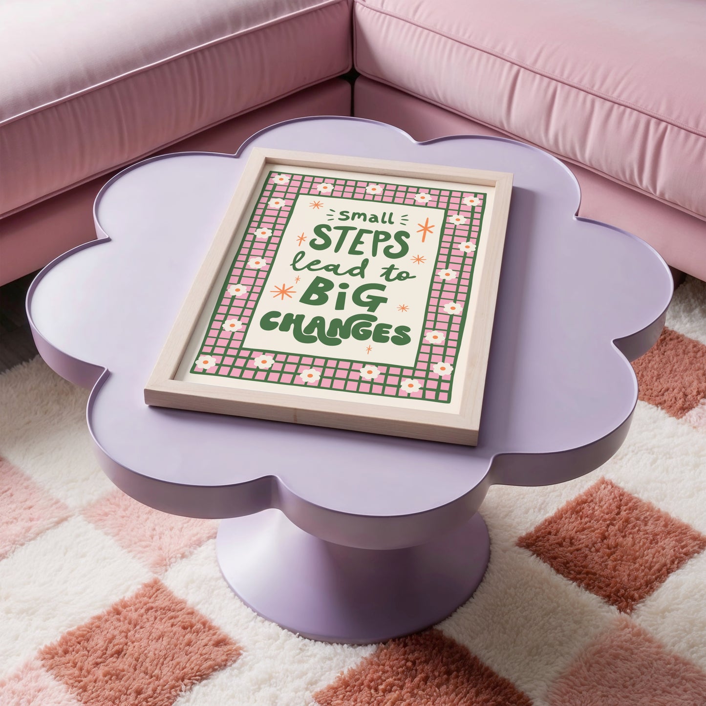 A positive quote print that reads 'small steps lead to big changes' in green hand writing. Around the quote is a hand drawn pink and green checkered border with daisy doodles.