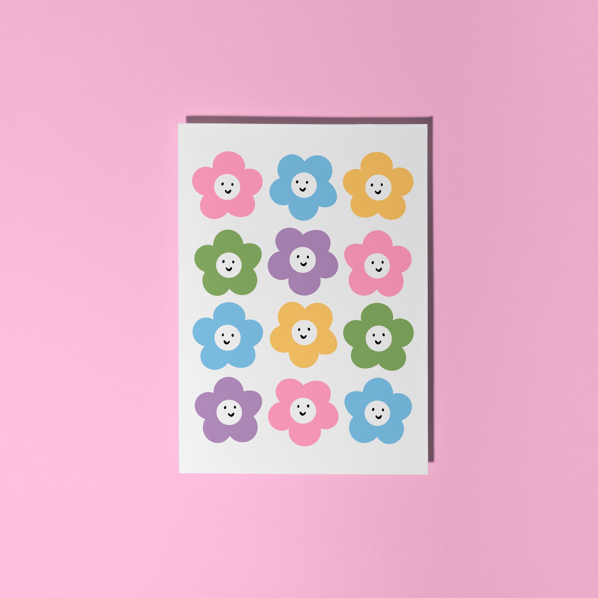 A greetings card with 12 different coloured smiling daisies on the front.