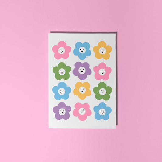 A greetings card with 12 different coloured smiling daisies on the front.