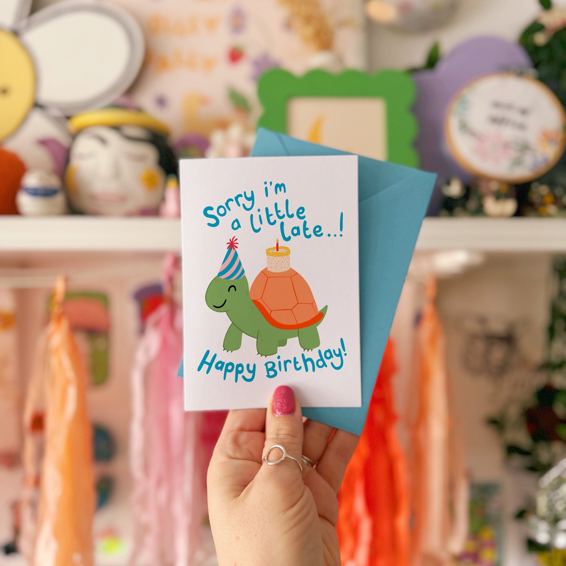 Birthday card with a tortoise wearing a party hat and text on a blue background